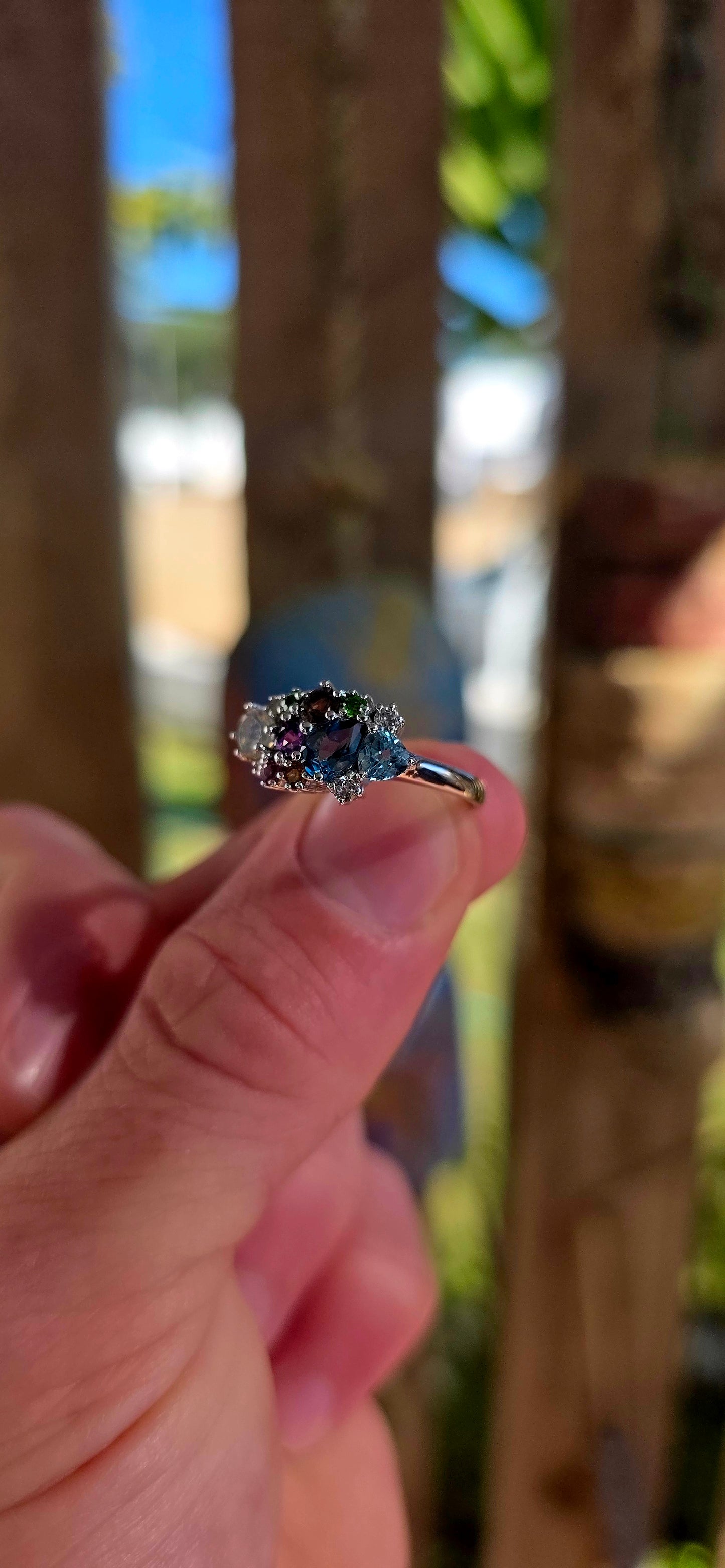 An enchanting sterling silver cluster ring finished in luminous rhodium plating, this marvelous piece feels like a tiny treasure chest of gemstones gathered from across the cosmos.