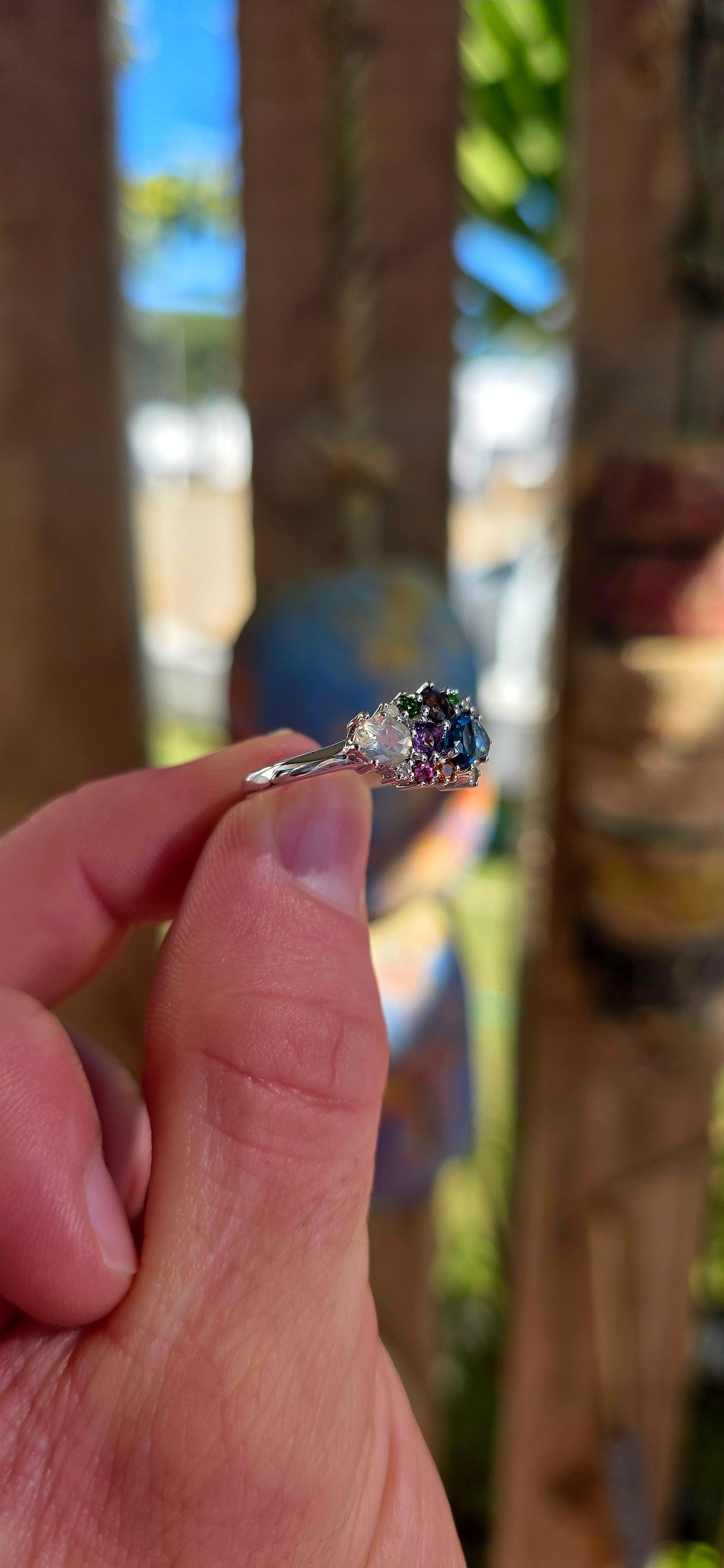 An enchanting sterling silver cluster ring finished in luminous rhodium plating, this marvelous piece feels like a tiny treasure chest of gemstones gathered from across the cosmos.