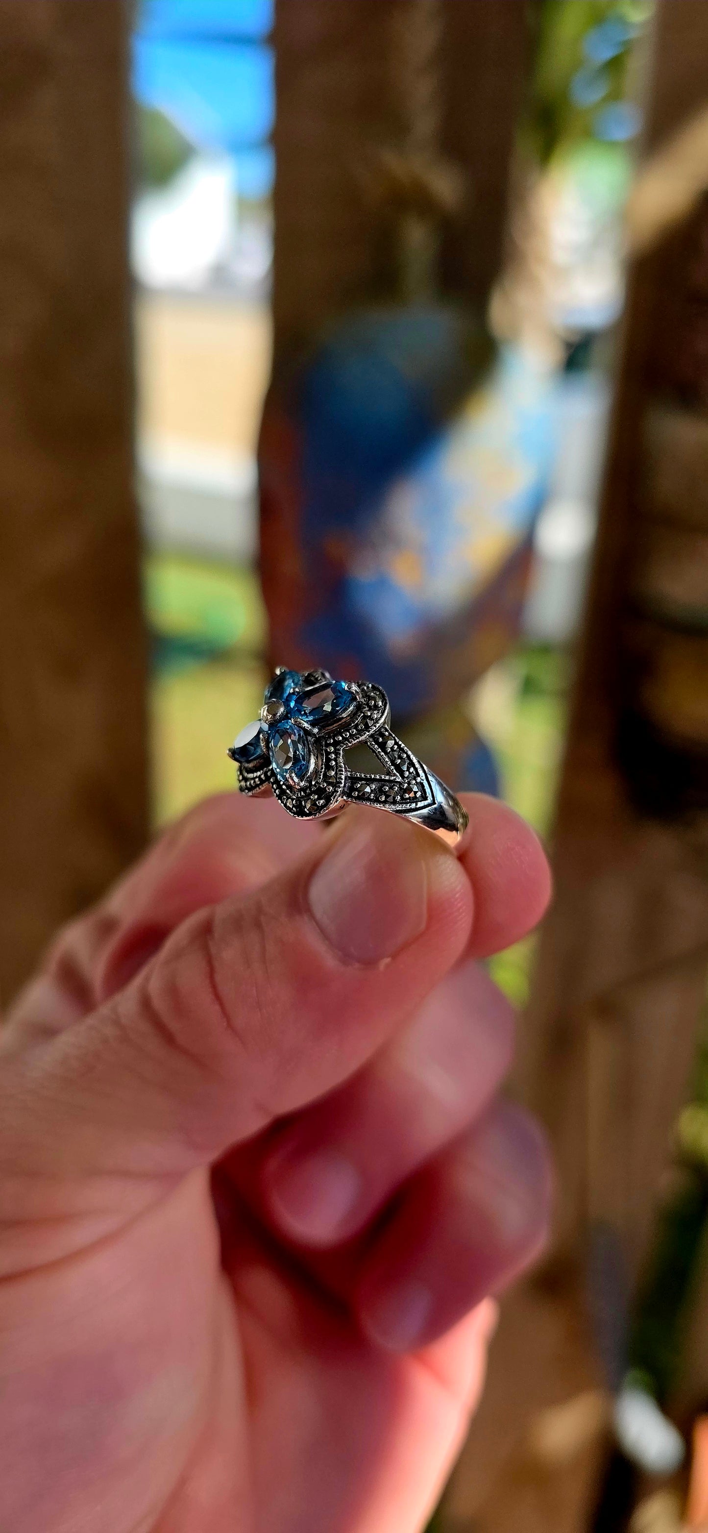 Enchanting sterling silver vintage revival dress ring featuring four pear-cut sky blue topaz gemstones arranged in the shape of a delicate flower.