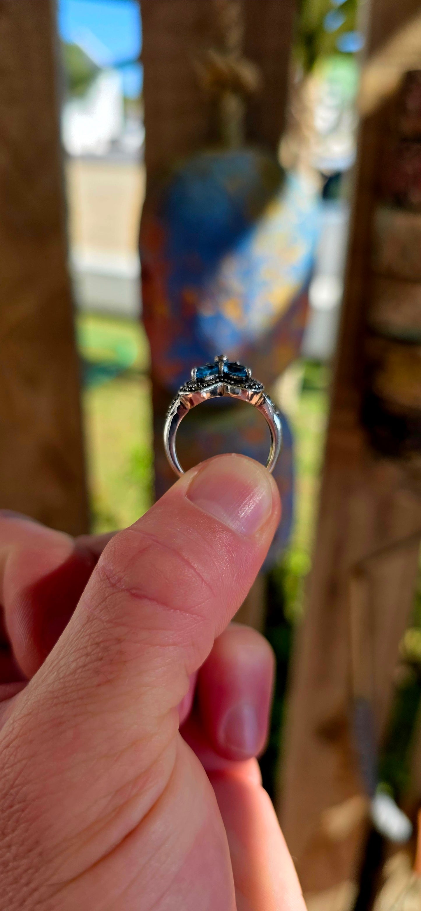 Enchanting sterling silver vintage revival dress ring featuring four pear-cut sky blue topaz gemstones arranged in the shape of a delicate flower.