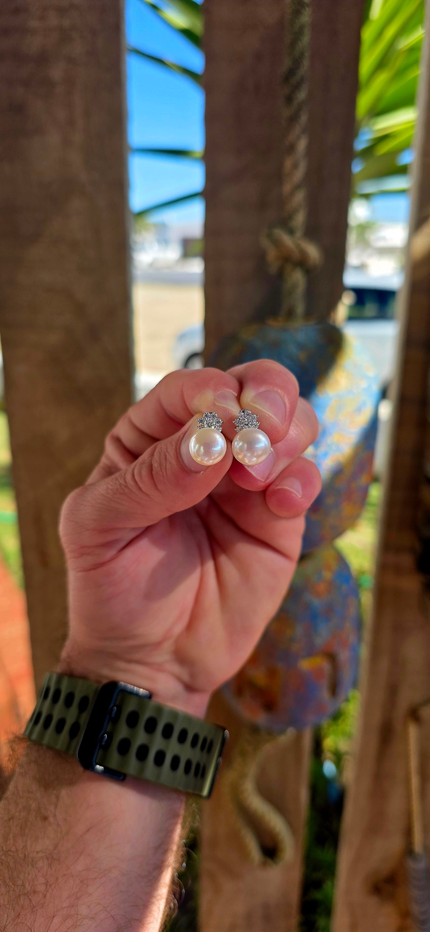 Beautiful luminous freshwater pearl stud earrings topped with delicate little crown motifs, each prong-set with sparkling round-cut cubic zirconia gemstones.