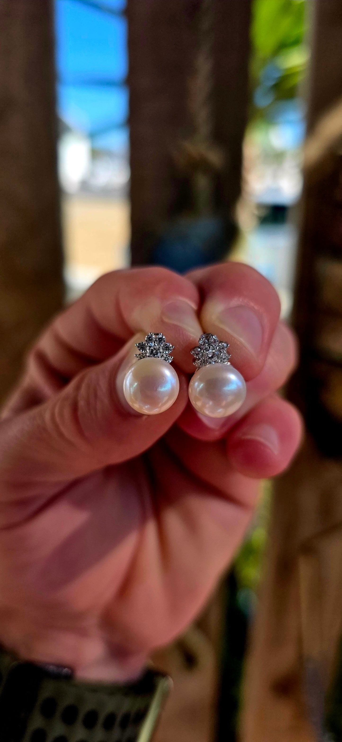 Beautiful luminous freshwater pearl stud earrings topped with delicate little crown motifs, each prong-set with sparkling round-cut cubic zirconia gemstones.