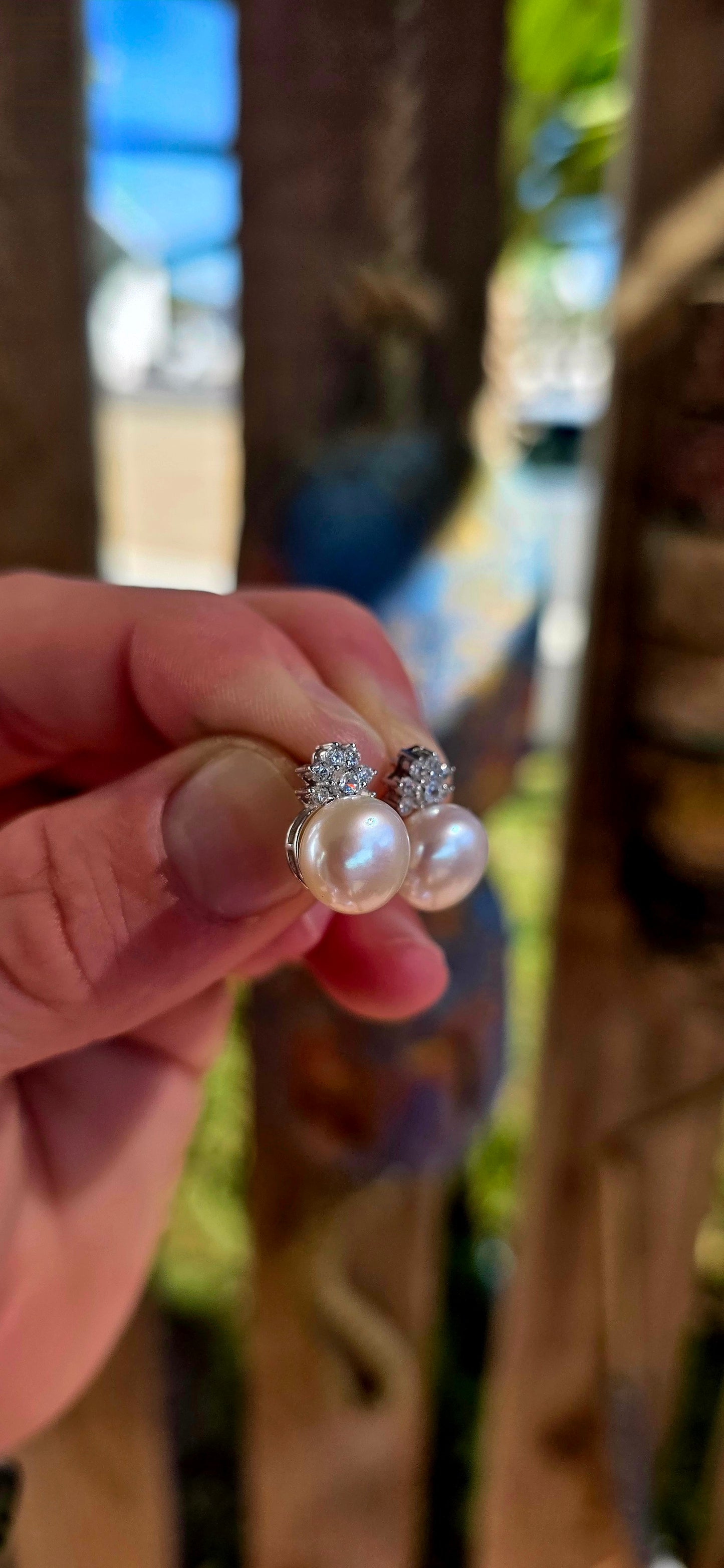 Beautiful luminous freshwater pearl stud earrings topped with delicate little crown motifs, each prong-set with sparkling round-cut cubic zirconia gemstones.