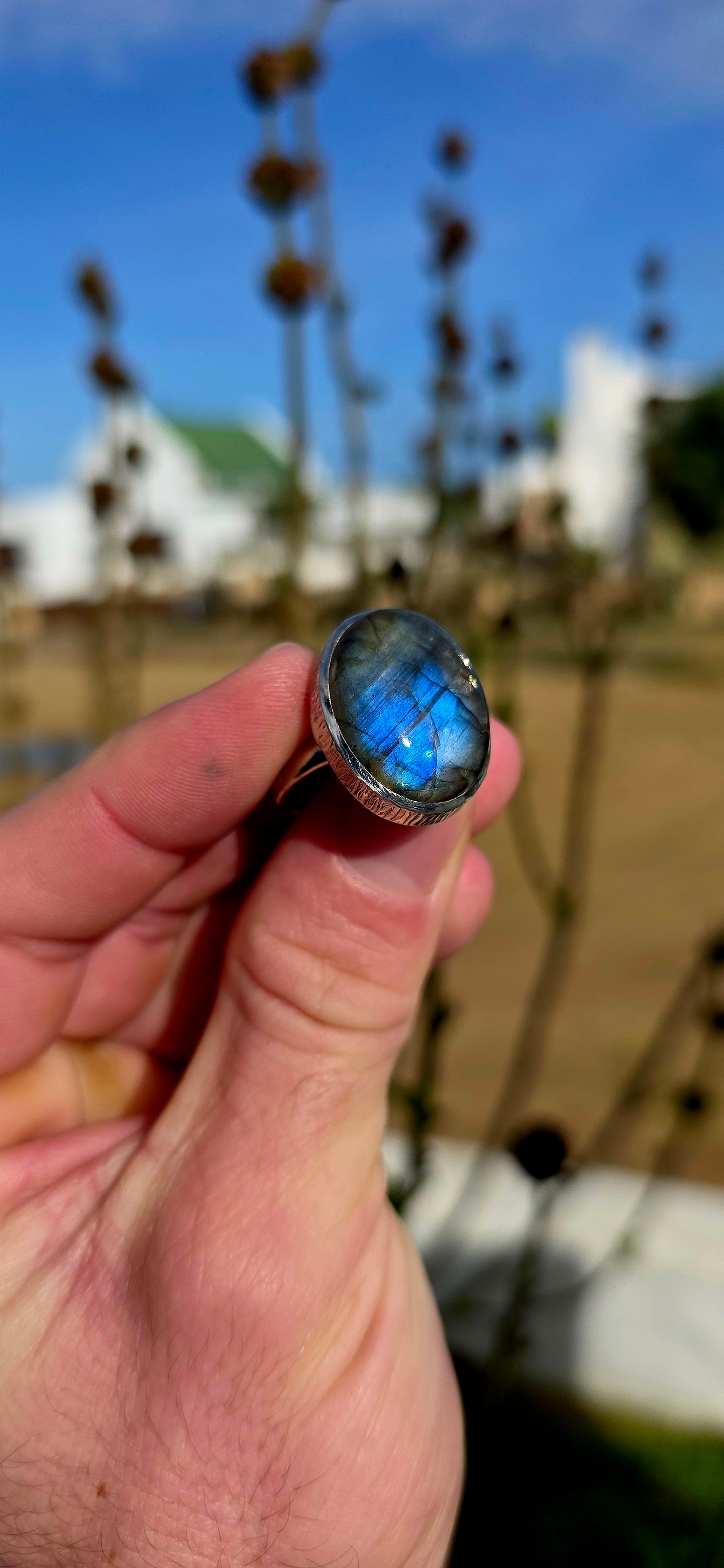 Beautiful sterling silver statement dress ring featuring a generously sized oval-cut labradorite cabochon in a sleek tube/bezel setting.