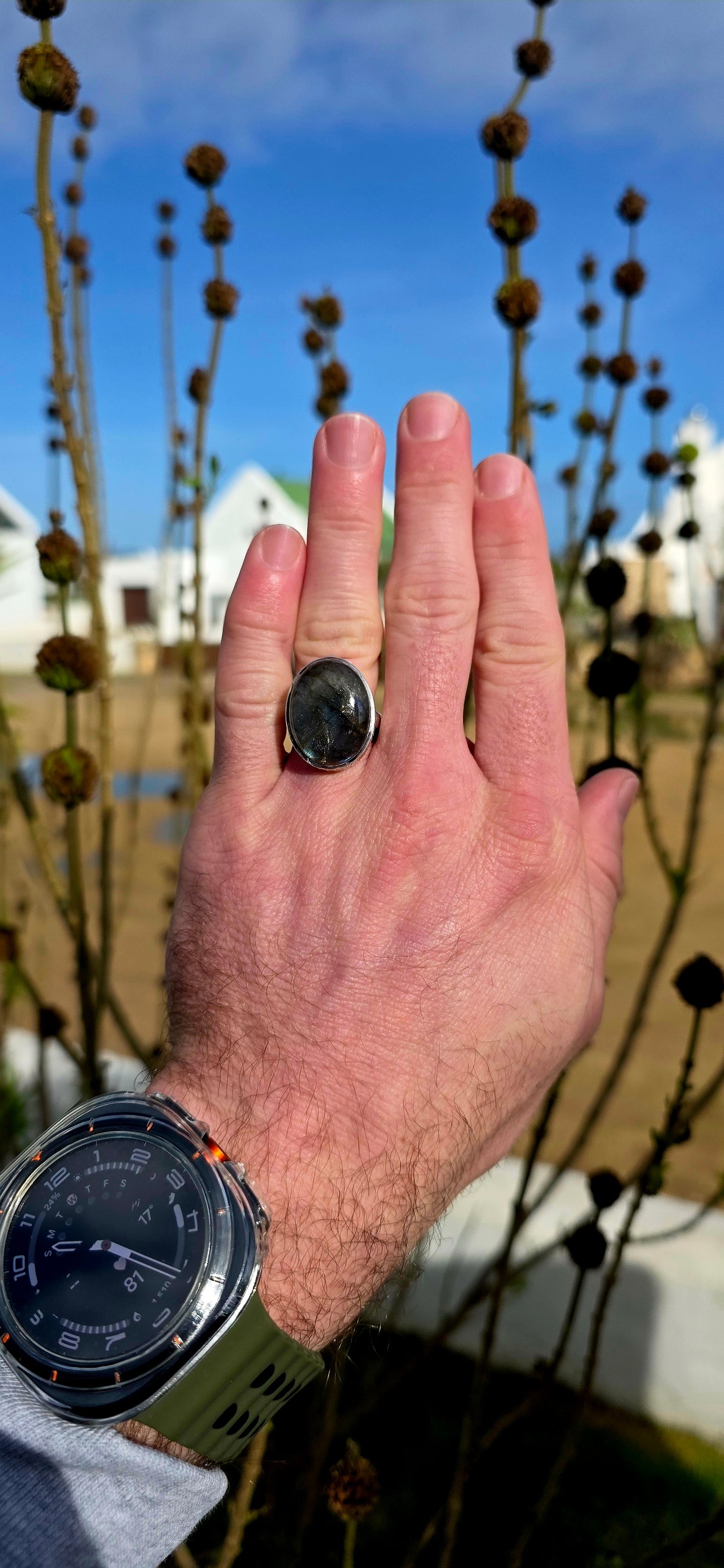 Beautiful sterling silver statement dress ring featuring a generously sized oval-cut labradorite cabochon in a sleek tube/bezel setting.