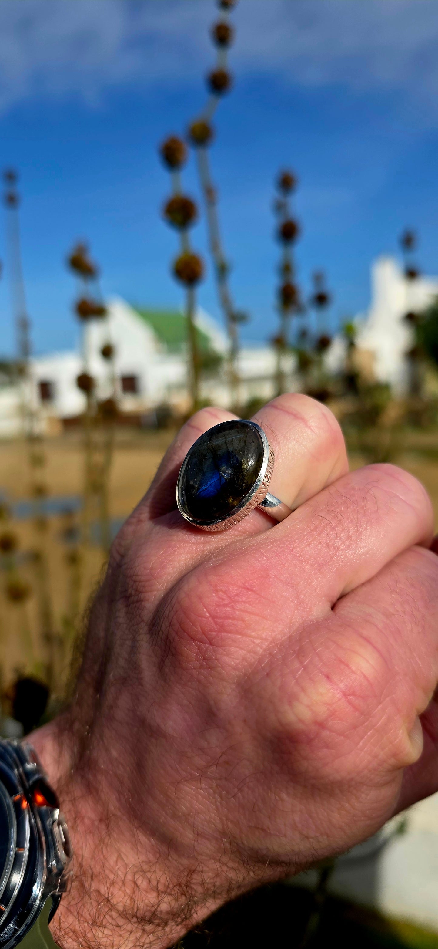 Beautiful sterling silver statement dress ring featuring a generously sized oval-cut labradorite cabochon in a sleek tube/bezel setting.