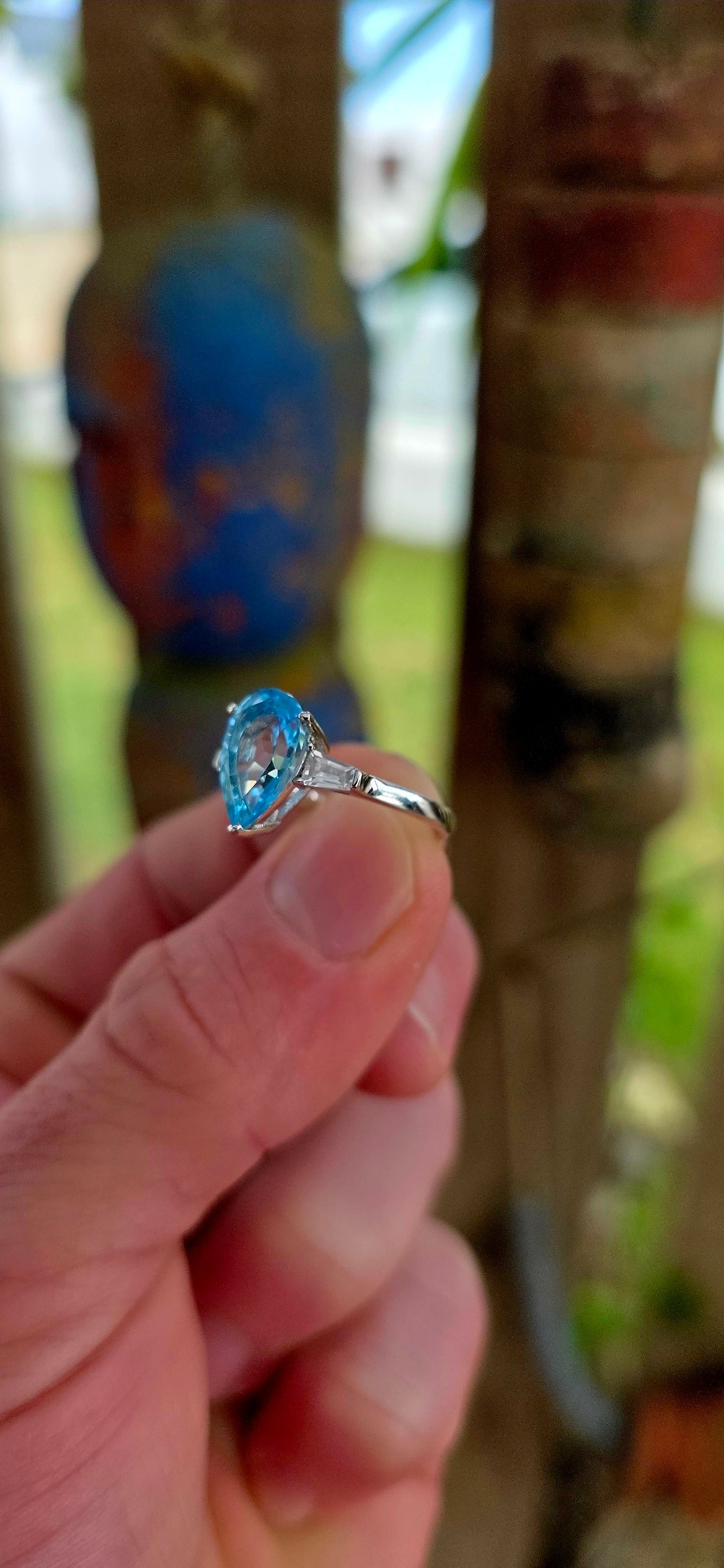 This elegant Art Deco revival trilogy ring is crafted in sterling silver and crowned with a generously sized pear-cut Swiss blue topaz in a classic prong setting.
