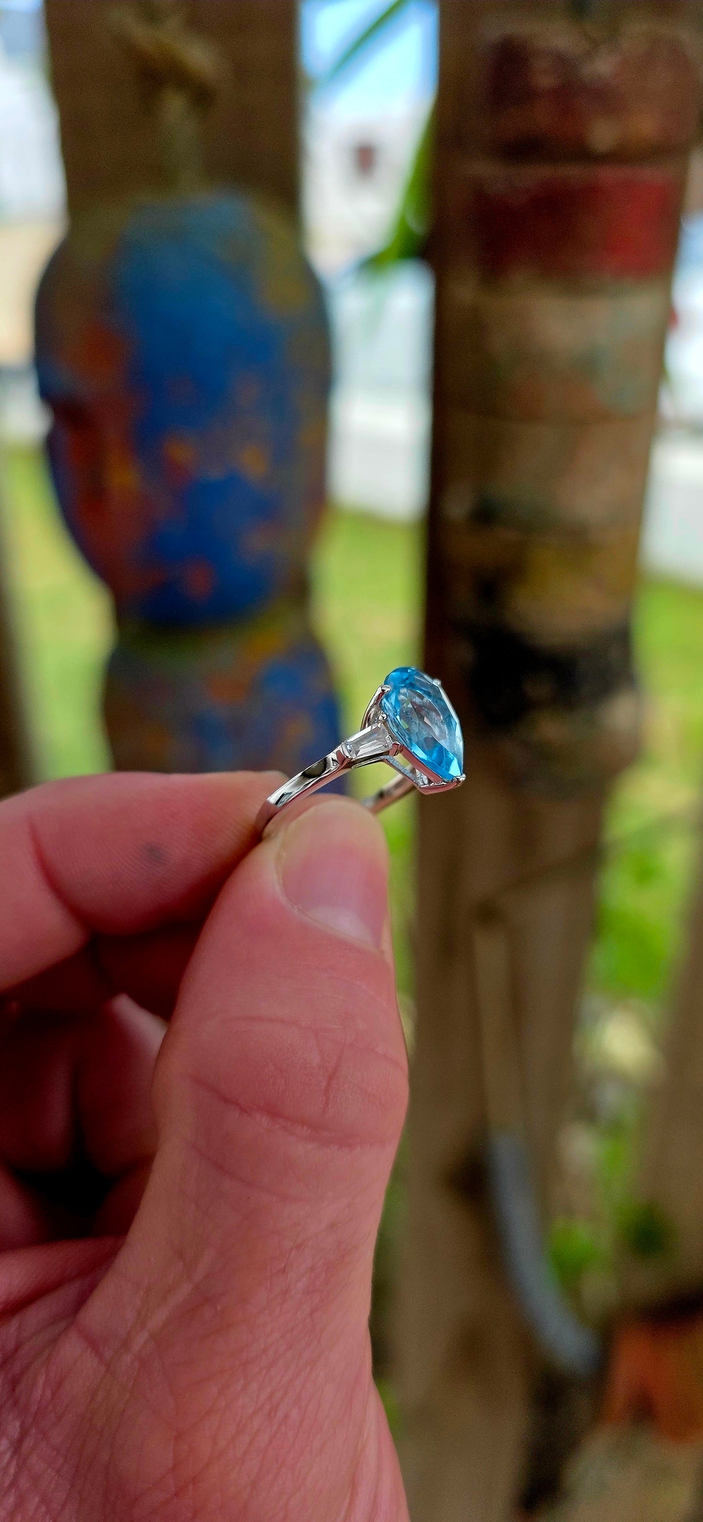 This elegant Art Deco revival trilogy ring is crafted in sterling silver and crowned with a generously sized pear-cut Swiss blue topaz in a classic prong setting.