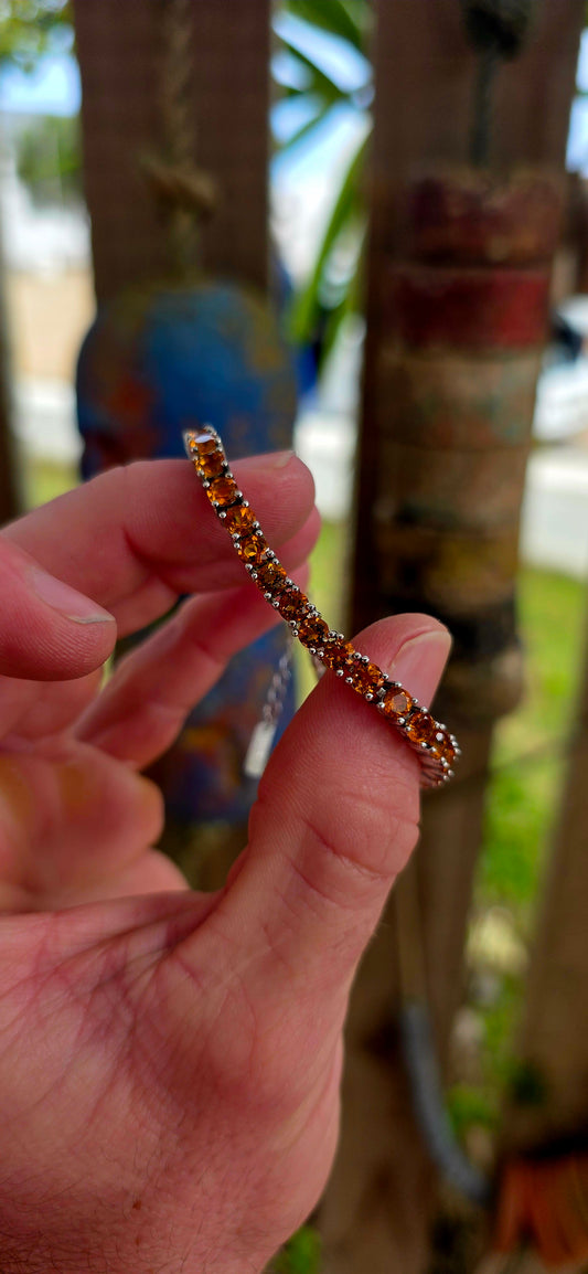 This beautiful sterling silver tennis bracelet features an elegant line-up of 37 vibrant orangy-citrine gemstones, each delicately prong set.
