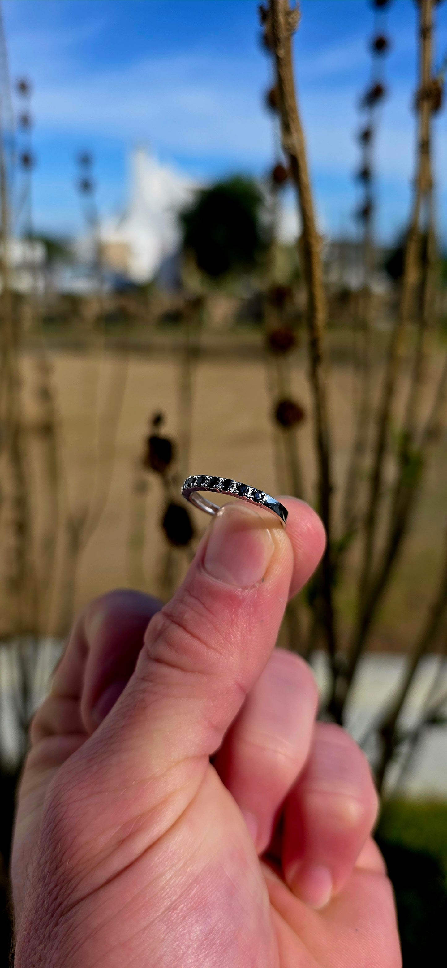 Crafted in sterling silver, this dainty stacking ring is beautifully set with nine round-cut blue sapphires in a delicate combination of prong and flush-style settings.