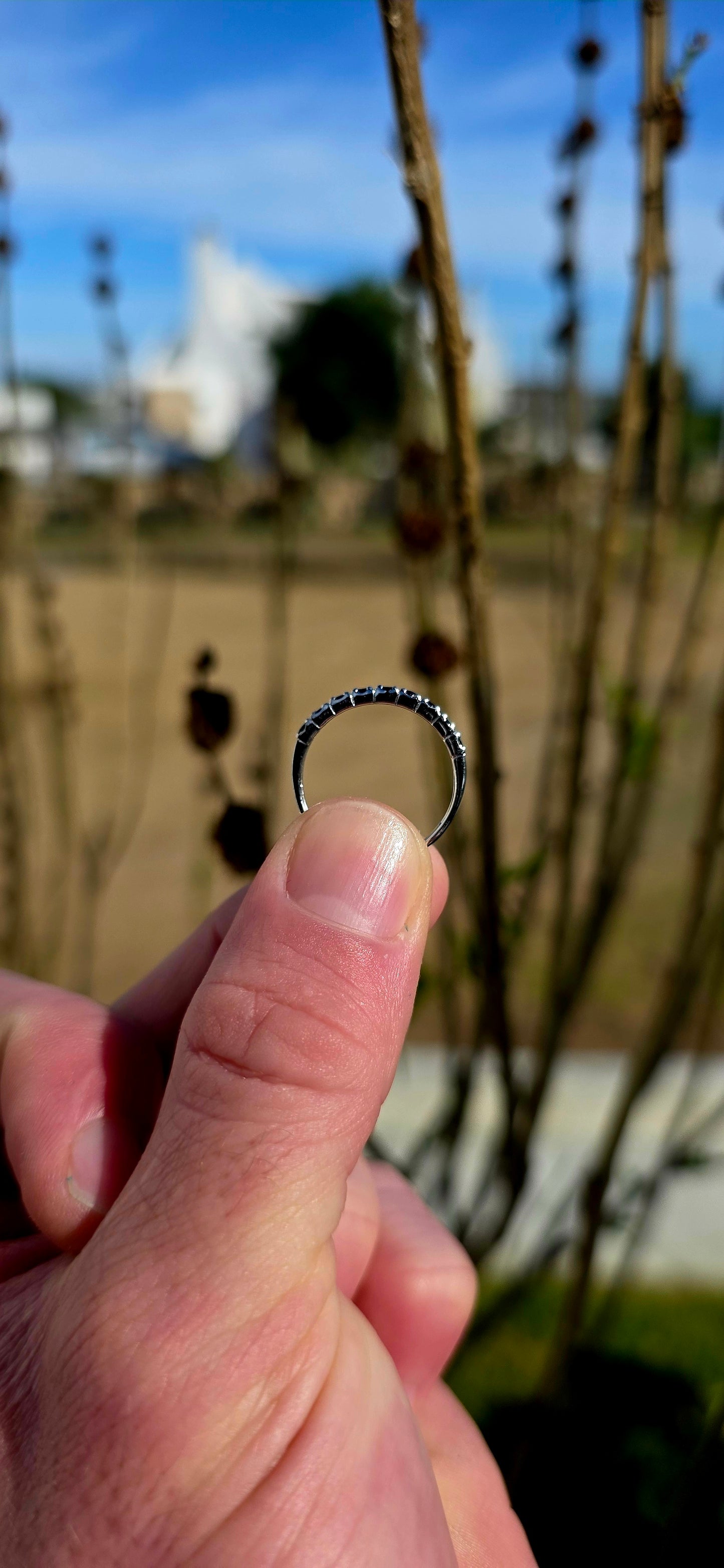 Crafted in sterling silver, this dainty stacking ring is beautifully set with nine round-cut blue sapphires in a delicate combination of prong and flush-style settings.