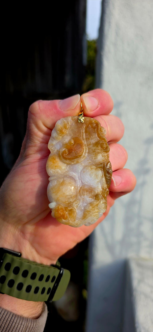 A magnificent and large sized antique Chinese handcarved jadeite jade pendant, masterfully sculpted from richly mottled brown and white jadeite and adorned with auspicious symbolic fruit carvings and sacred lingzhi mushrooms.