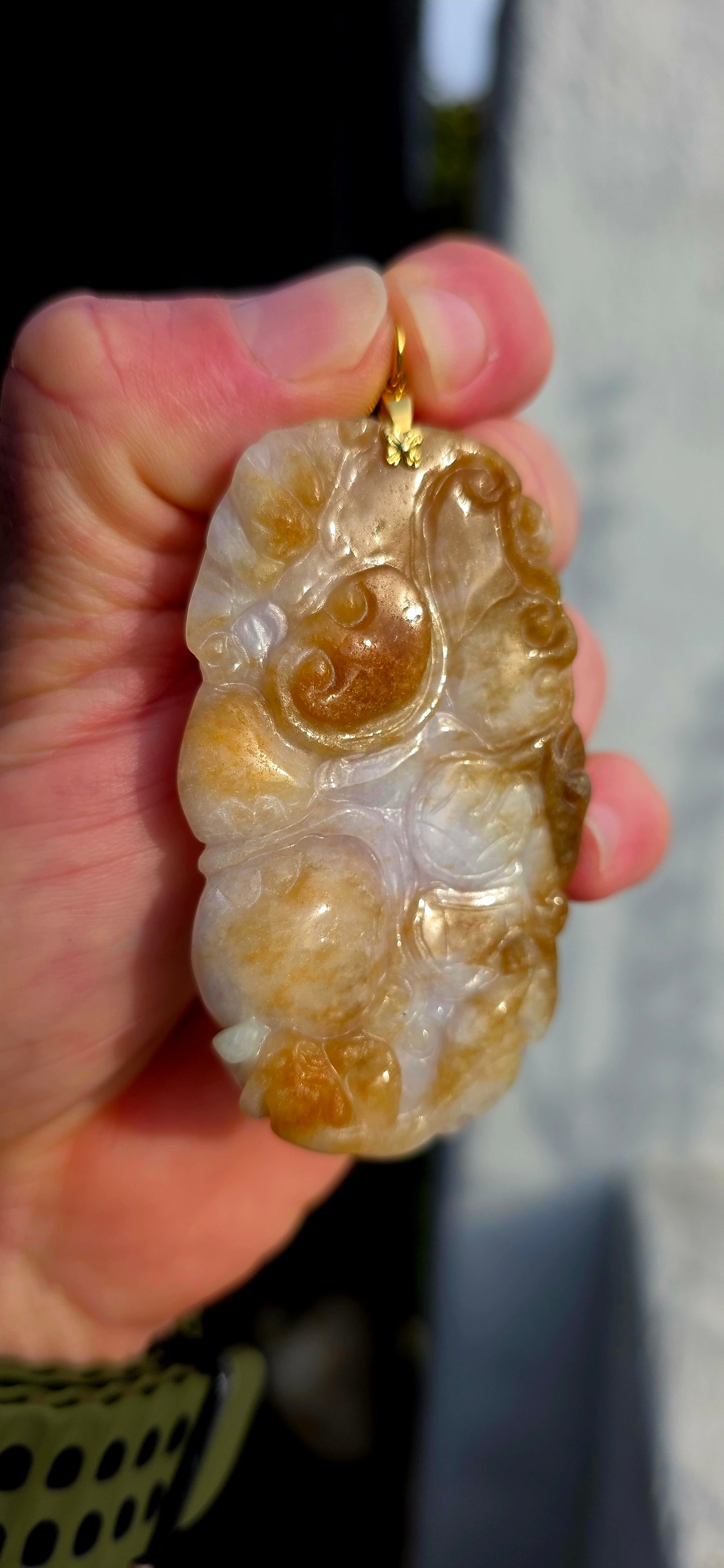 A magnificent and large sized antique Chinese handcarved jadeite jade pendant, masterfully sculpted from richly mottled brown and white jadeite and adorned with auspicious symbolic fruit carvings and sacred lingzhi mushrooms.
