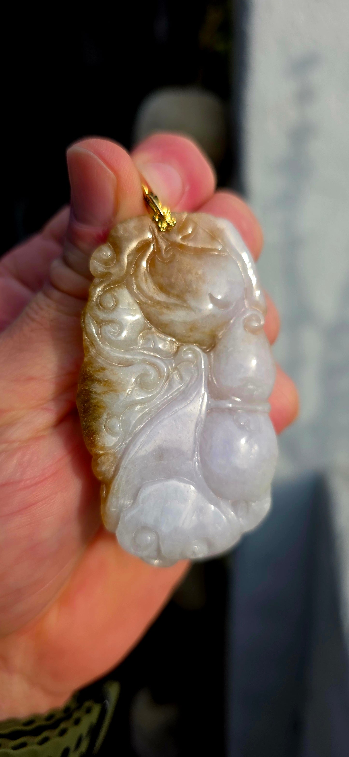 A magnificent and large sized antique Chinese handcarved jadeite jade pendant, masterfully sculpted from richly mottled brown and white jadeite and adorned with auspicious symbolic fruit carvings and sacred lingzhi mushrooms.