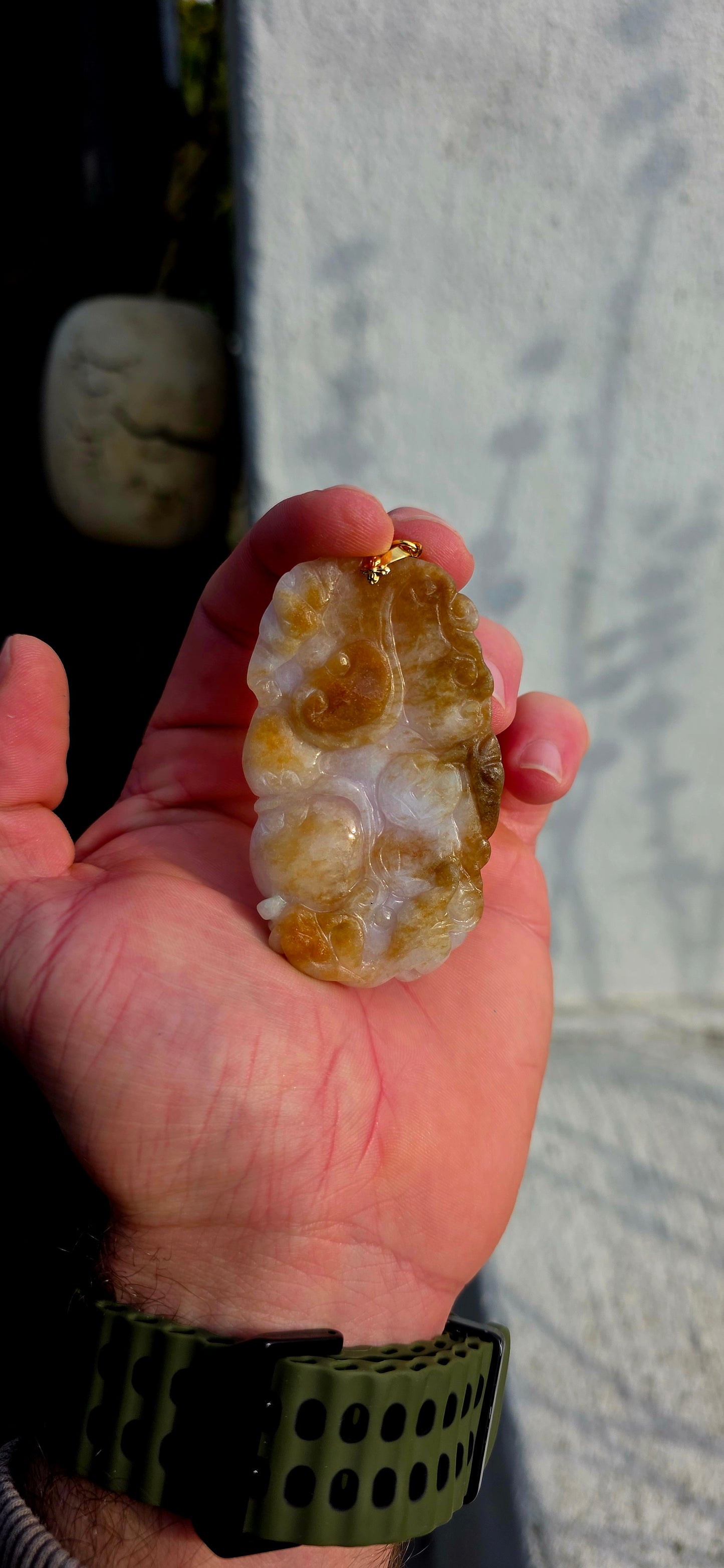 A magnificent and large sized antique Chinese handcarved jadeite jade pendant, masterfully sculpted from richly mottled brown and white jadeite and adorned with auspicious symbolic fruit carvings and sacred lingzhi mushrooms.