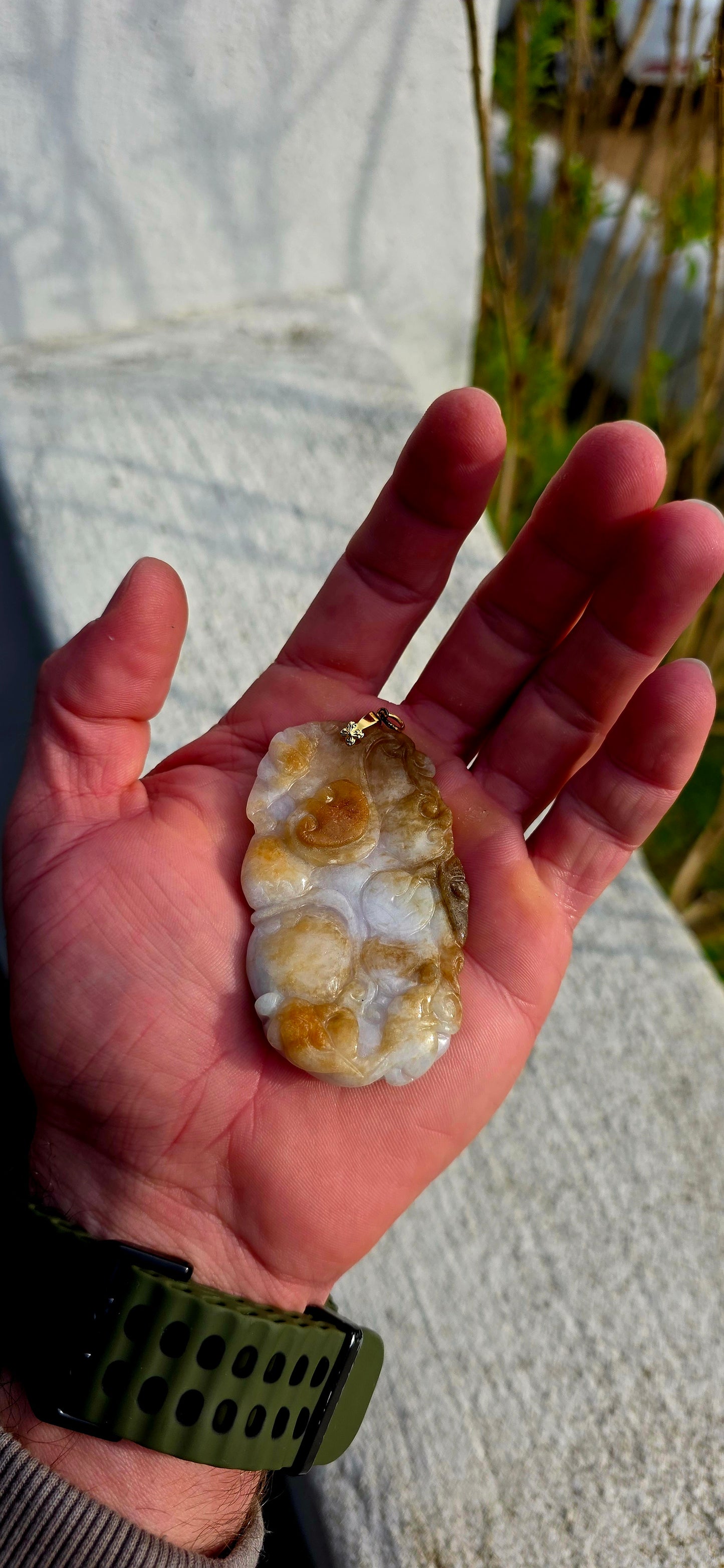 A magnificent and large sized antique Chinese handcarved jadeite jade pendant, masterfully sculpted from richly mottled brown and white jadeite and adorned with auspicious symbolic fruit carvings and sacred lingzhi mushrooms.