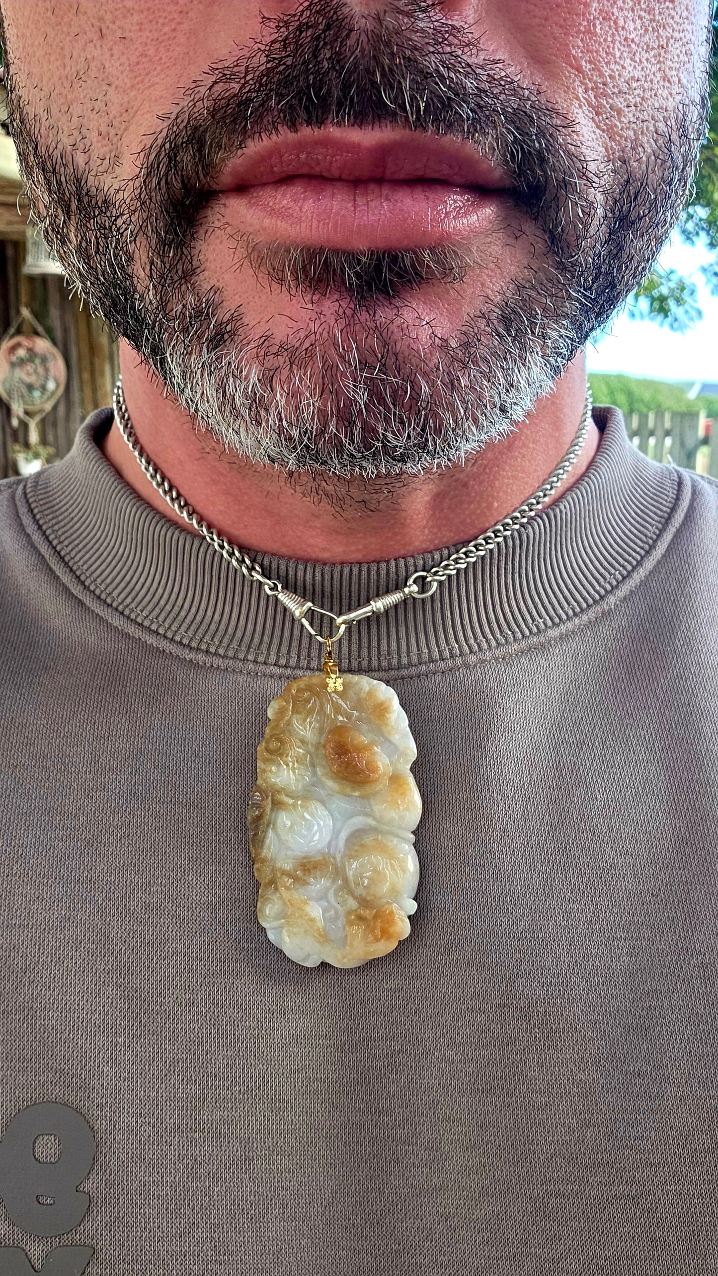 A magnificent and large sized antique Chinese handcarved jadeite jade pendant, masterfully sculpted from richly mottled brown and white jadeite and adorned with auspicious symbolic fruit carvings and sacred lingzhi mushrooms.