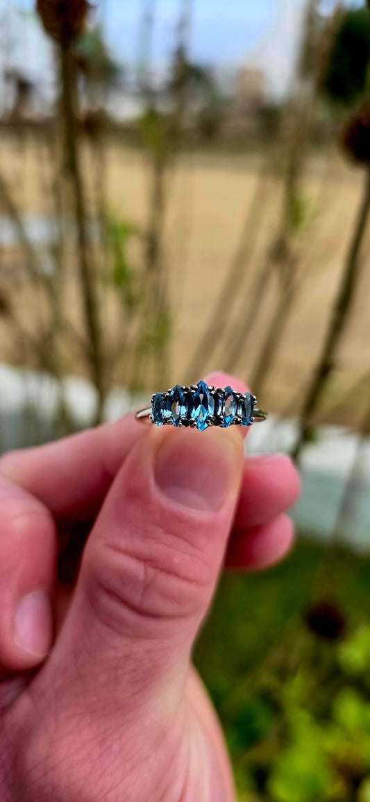 Delicate, dreamy, and filled with icy sparkle… this enchanting sterling silver ring is adorned with five marquise-cut sky blue topaz gemstones arranged in a graceful crown-like formation.