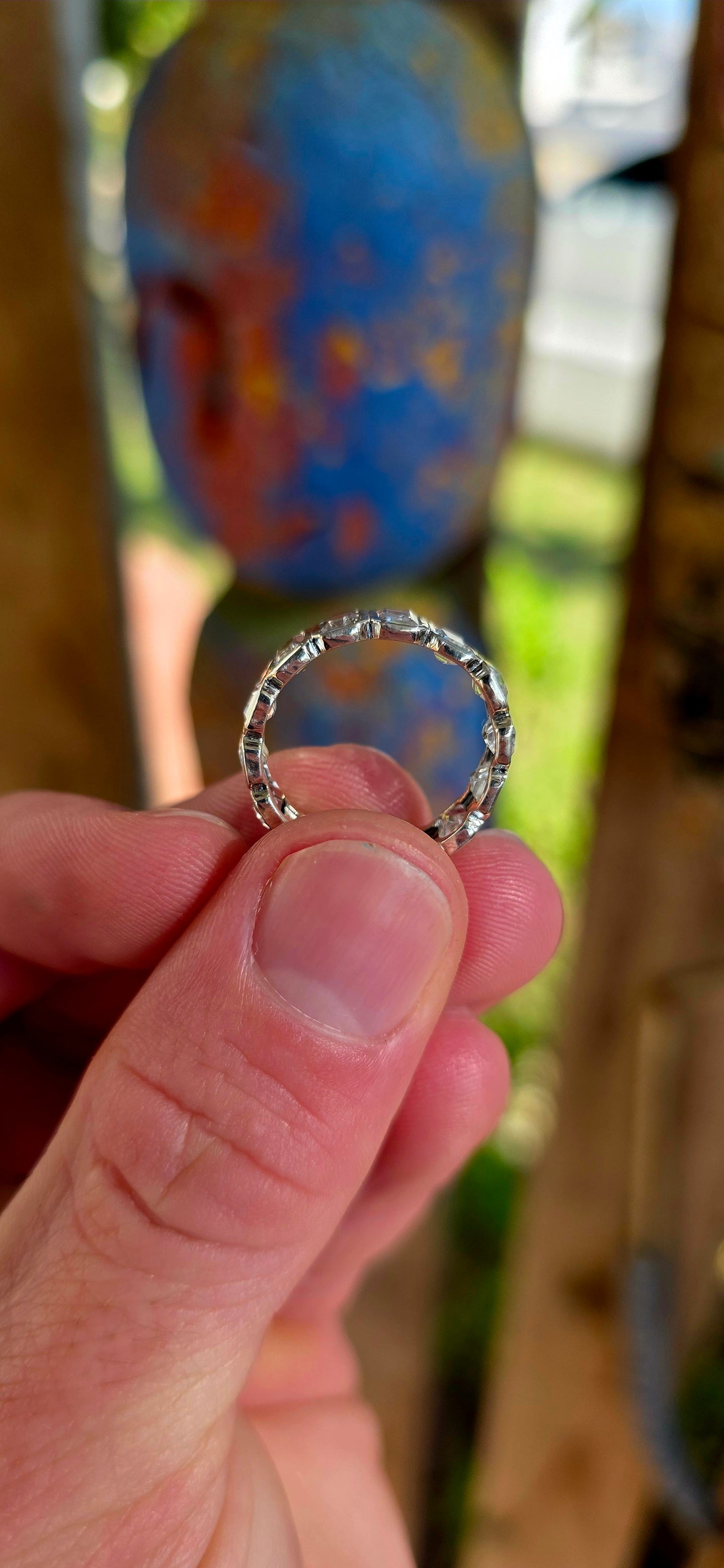 A truly breathtaking sterling silver full eternity ring, shimmering with fourteen emerald-cut white topaz gemstones set continuously all the way around the band in sleek tube settings.