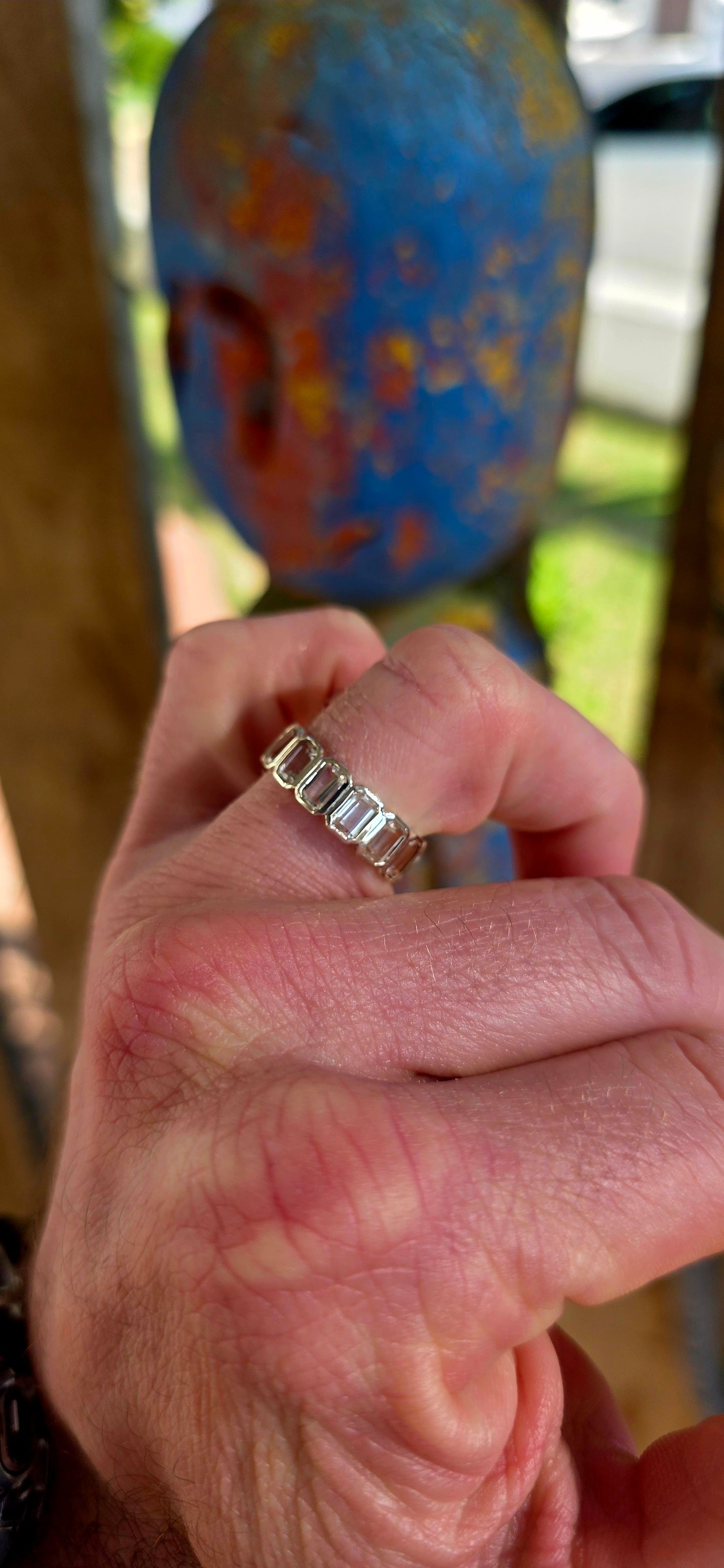 A truly breathtaking sterling silver full eternity ring, shimmering with fourteen emerald-cut white topaz gemstones set continuously all the way around the band in sleek tube settings.
