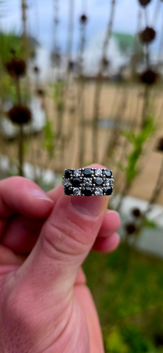 Striking and chunky sterling silver dress ring adorned with a dazzling arrangement of jet-black and crystal-clear cubic zirconia gemstones.