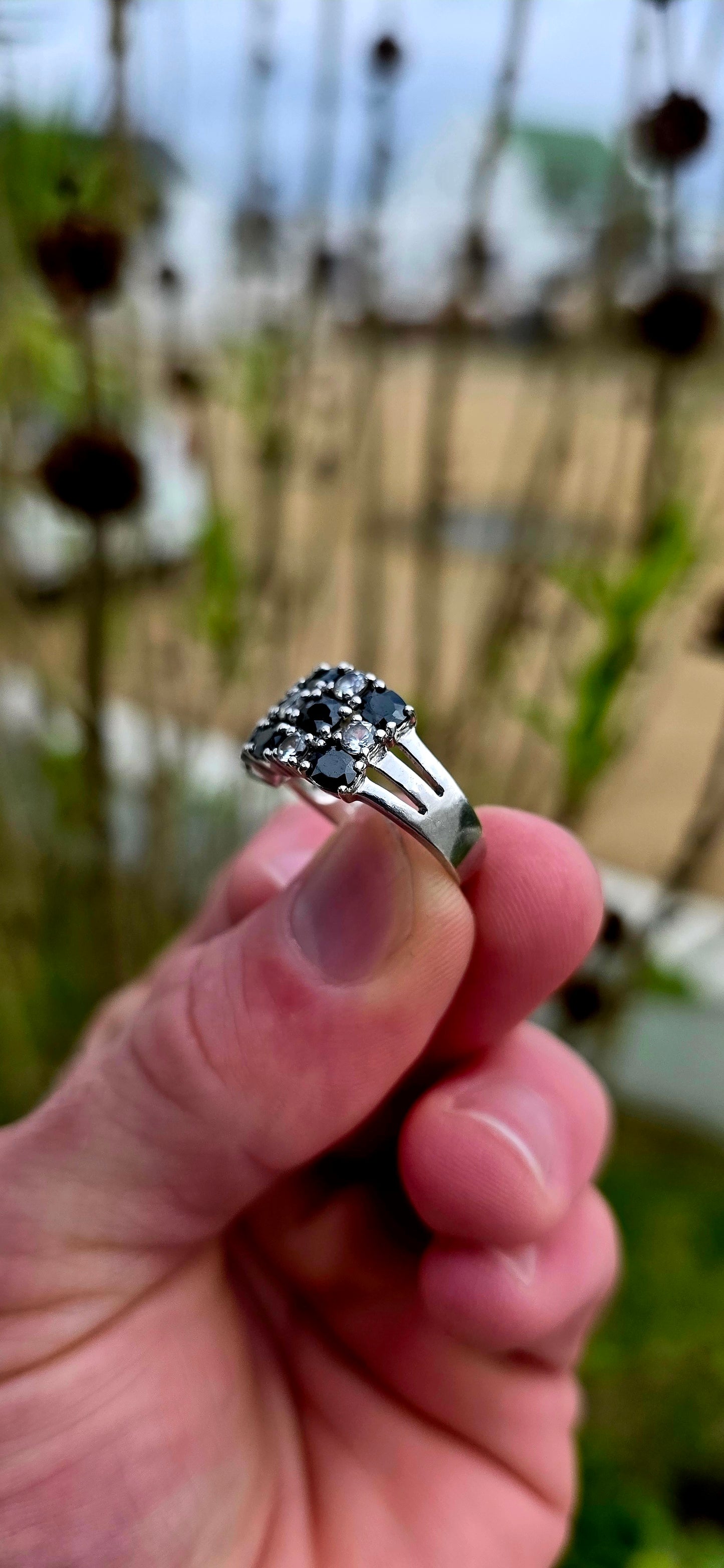 Striking and chunky sterling silver dress ring adorned with a dazzling arrangement of jet-black and crystal-clear cubic zirconia gemstones.