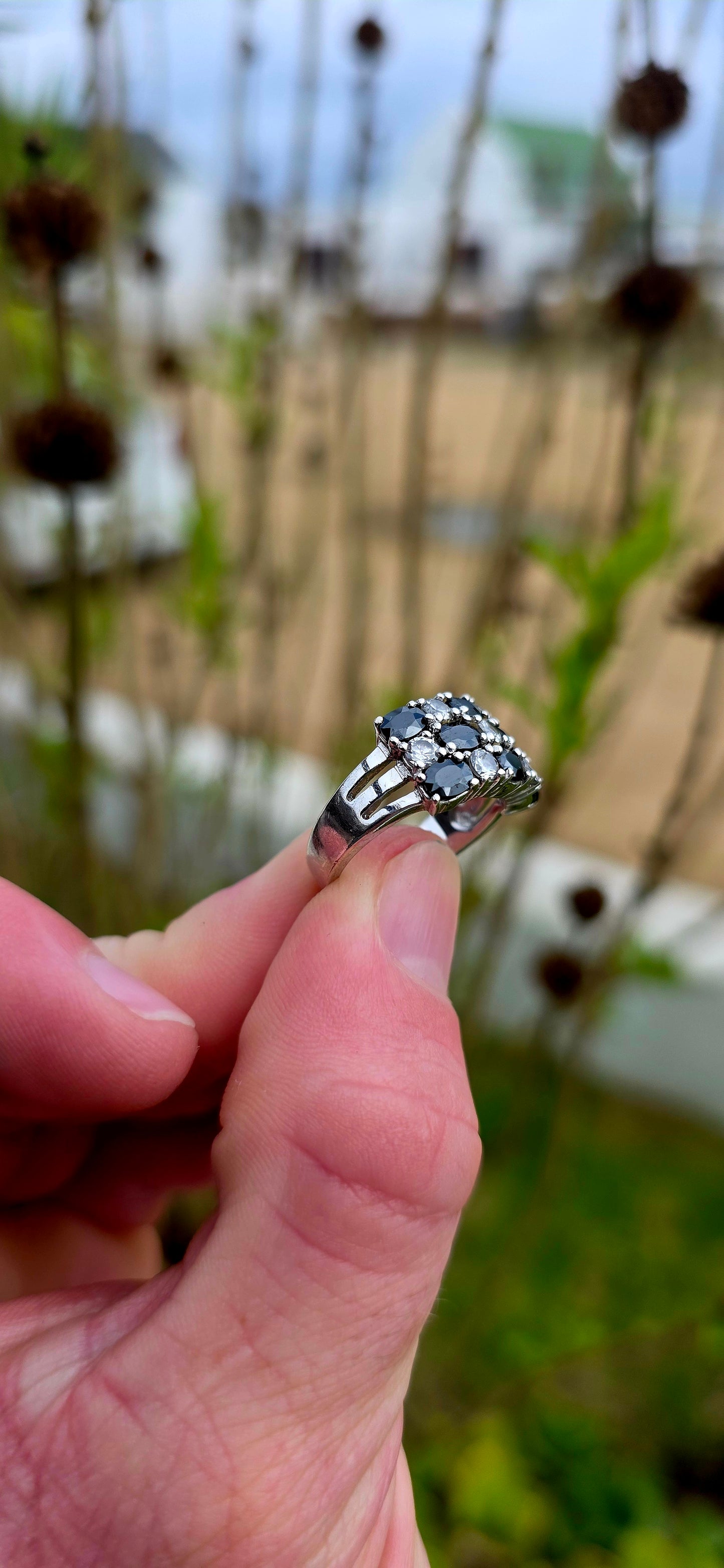 Striking and chunky sterling silver dress ring adorned with a dazzling arrangement of jet-black and crystal-clear cubic zirconia gemstones.