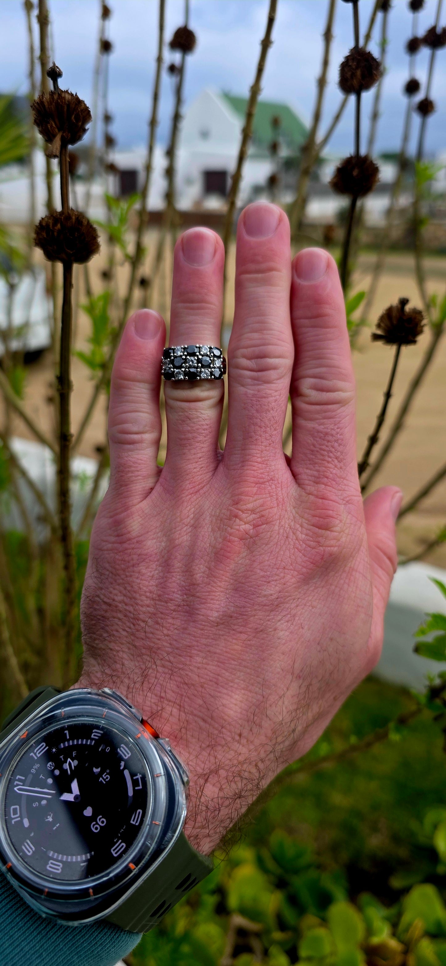 Striking and chunky sterling silver dress ring adorned with a dazzling arrangement of jet-black and crystal-clear cubic zirconia gemstones.