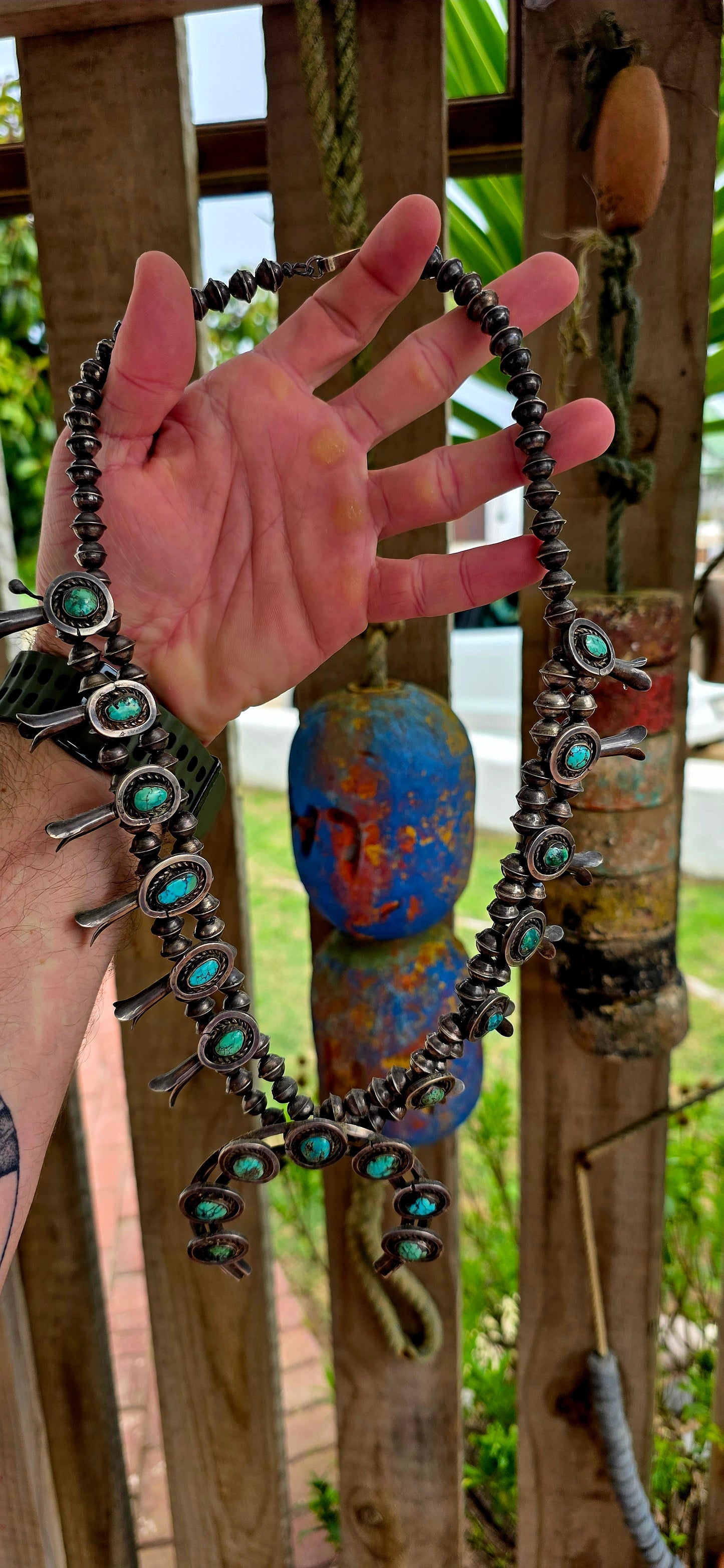 An absolutely breathtaking and exceptionally rare vintage Native American Navajo squash blossom necklace, masterfully handcrafted in sterling silver and adorned with vivid turquoise cabochons throughout.