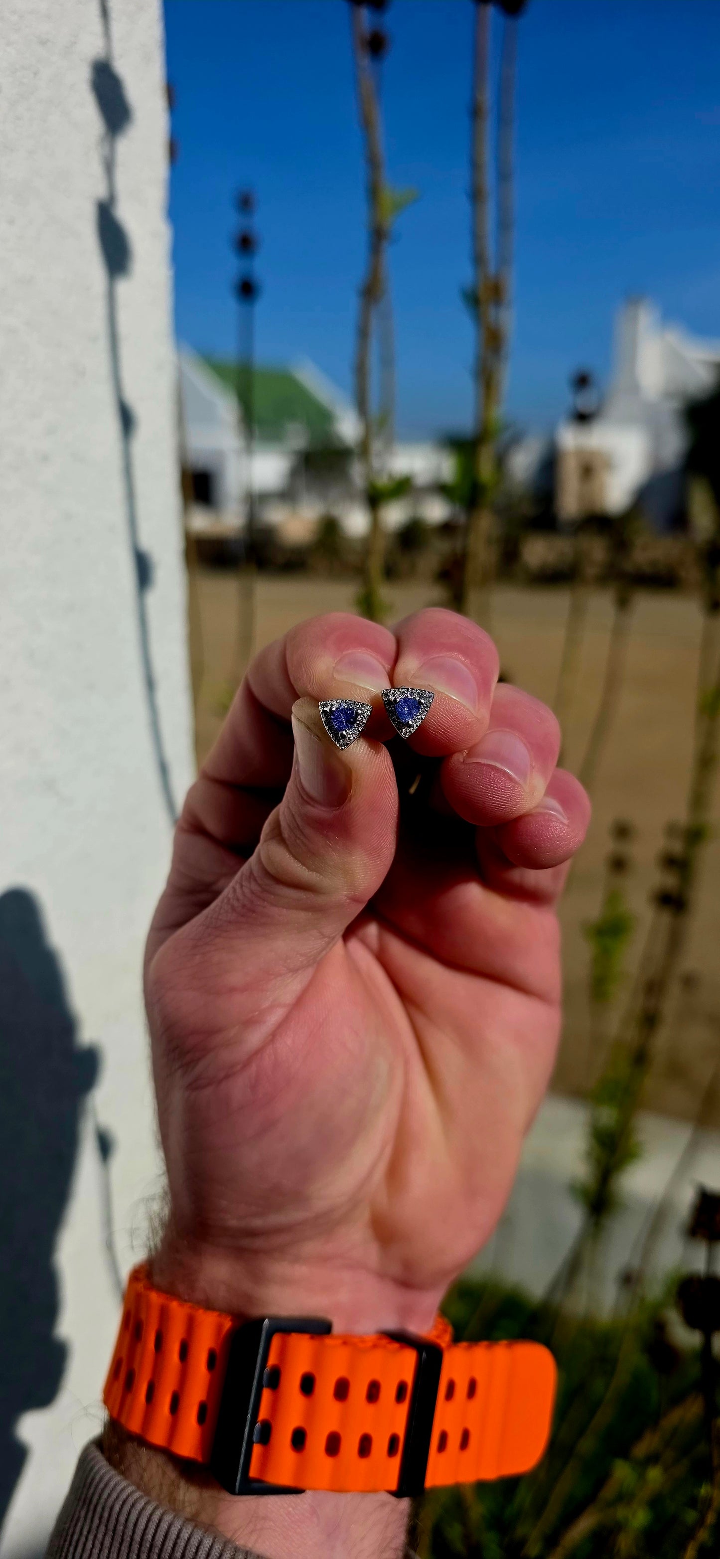 Crafted in sterling silver, these elegant stud earrings feature beautiful prong-set trillion cut tanzanites glowing in rich shades of violet-blue, indigo, and twilight lavender .