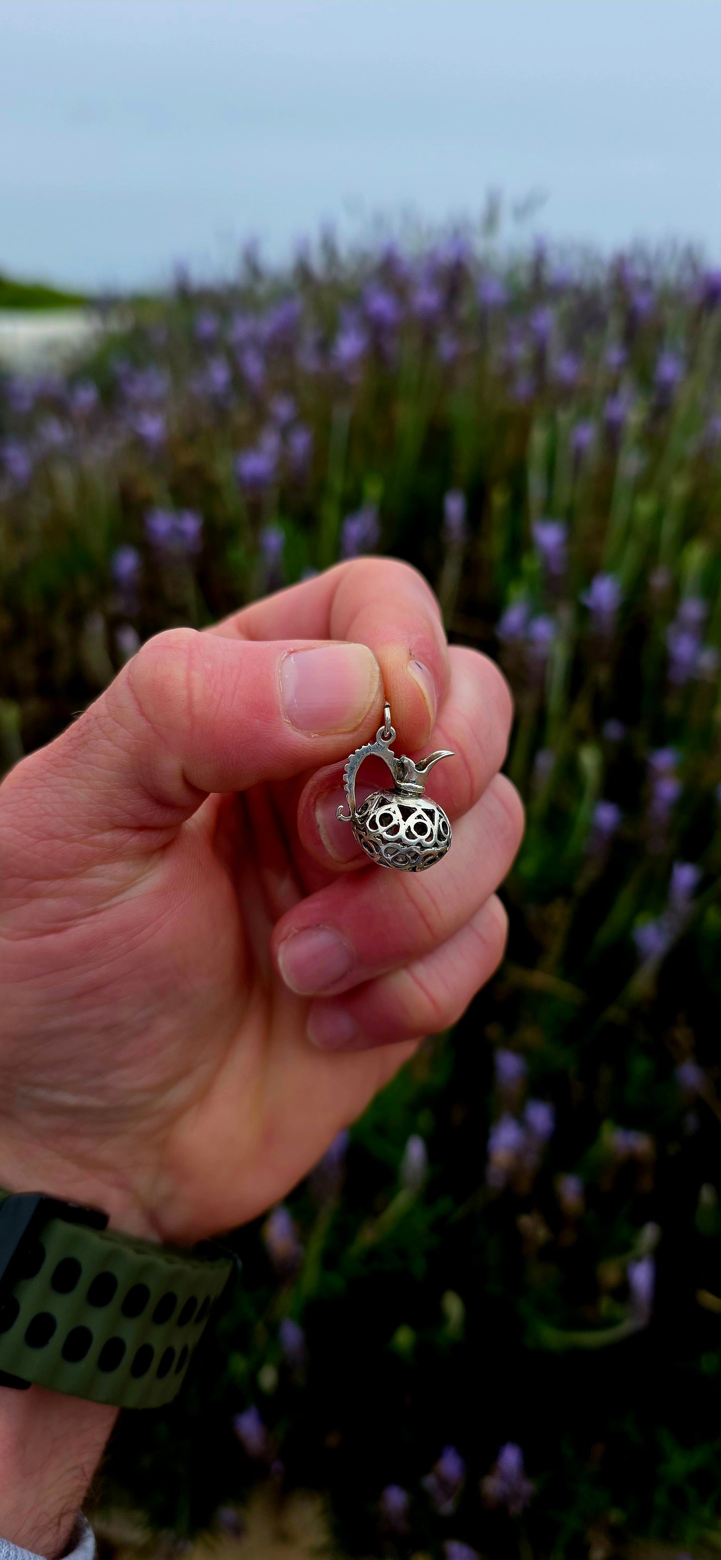 A wonderfully unusual vintage sterling silver charm crafted in the shape of an elegant water pitcher or ewer .