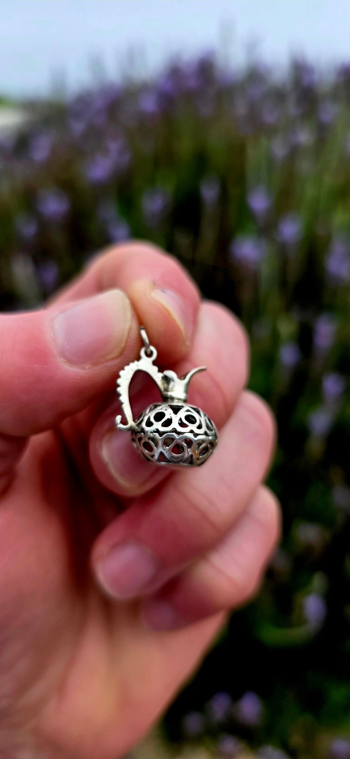 A wonderfully unusual vintage sterling silver charm crafted in the shape of an elegant water pitcher or ewer .