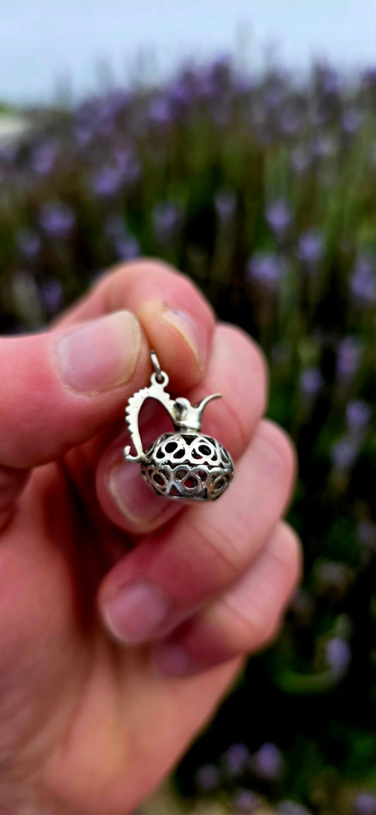 A wonderfully unusual vintage sterling silver charm crafted in the shape of an elegant water pitcher or ewer .