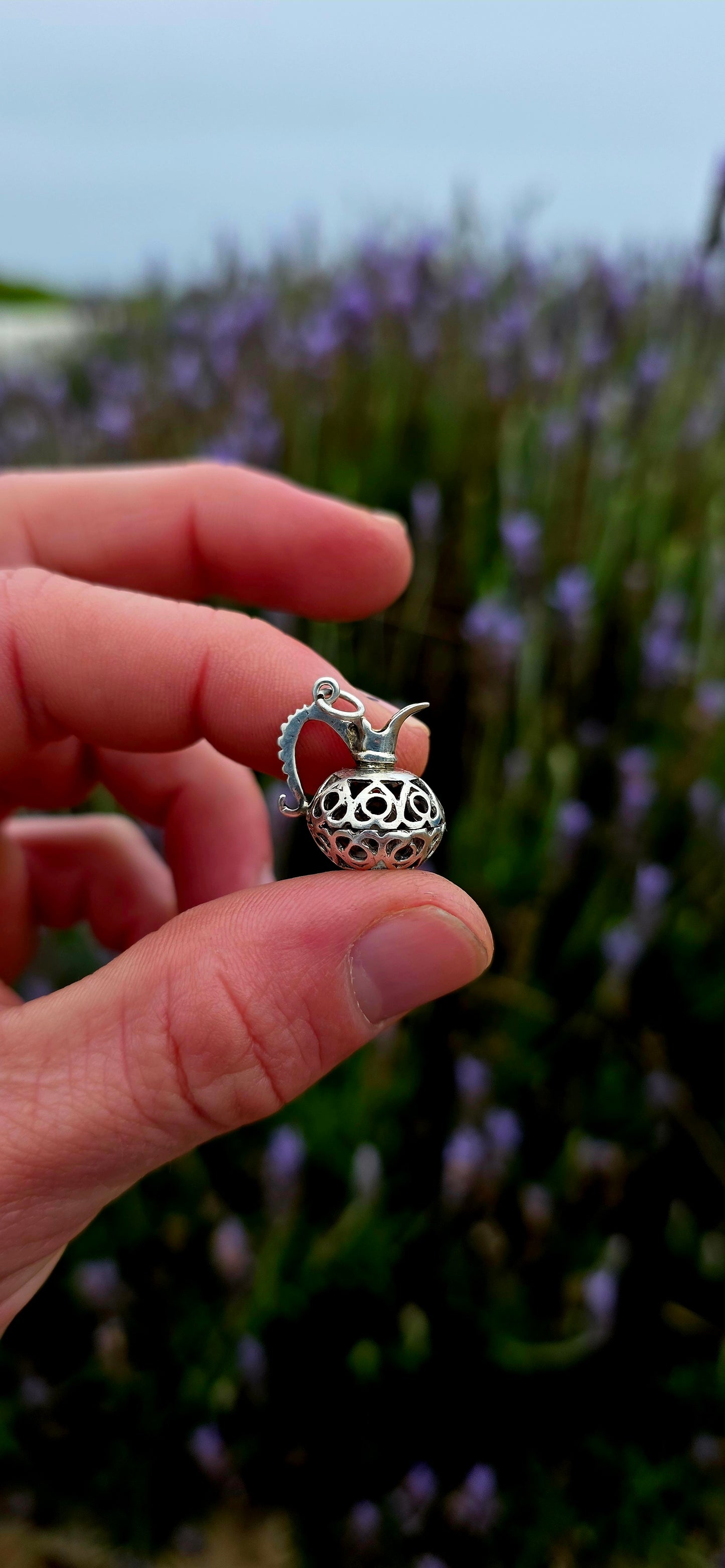 A wonderfully unusual vintage sterling silver charm crafted in the shape of an elegant water pitcher or ewer .