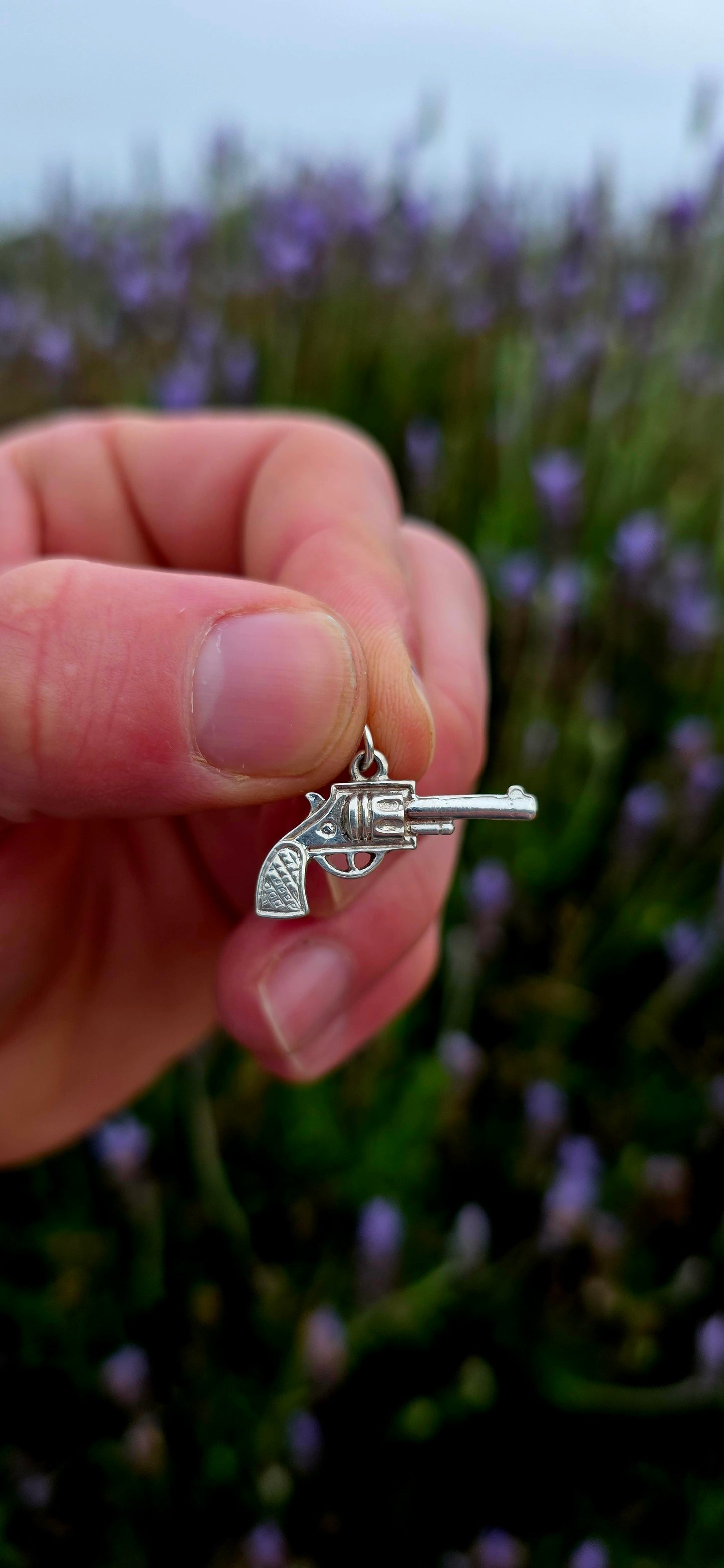 A wonderfully detailed vintage sterling silver charm crafted in the shape of a classic revolver-style pistol.