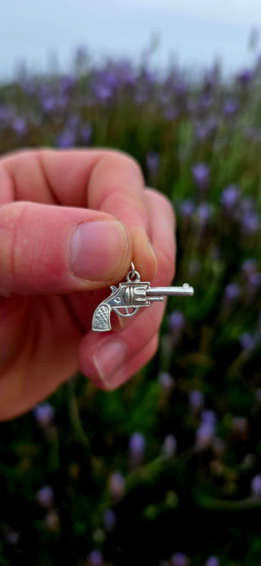 A wonderfully detailed vintage sterling silver charm crafted in the shape of a classic revolver-style pistol.