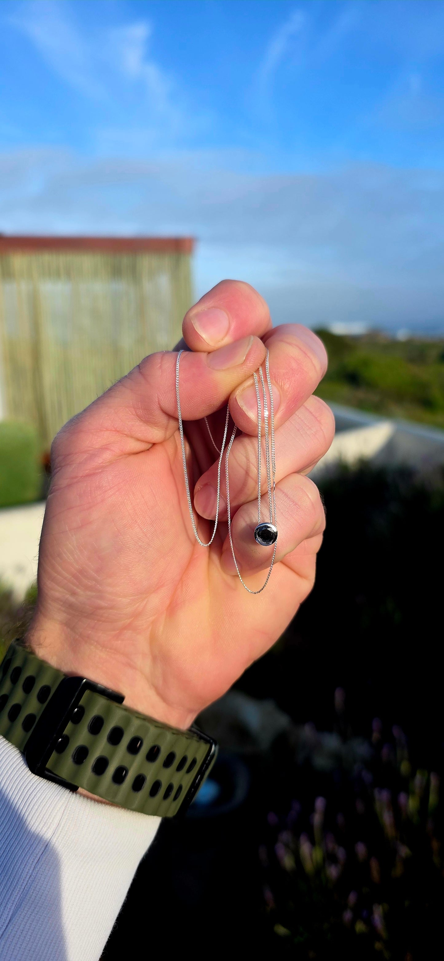 This elegant unisex sterling silver necklace embraces the beauty of simplicity, featuring a single round faceted black diamond securely nestled within a sleek tube setting.