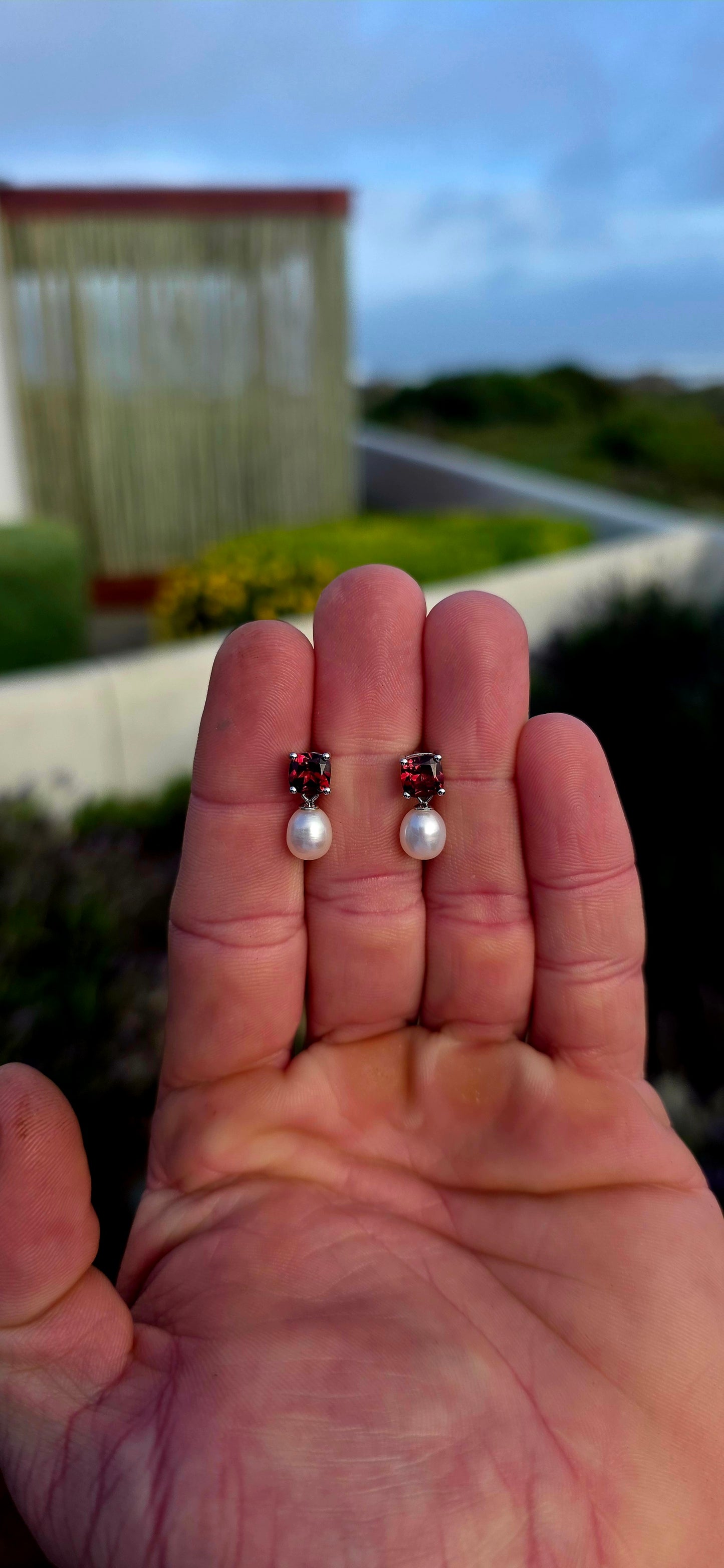 Crafted in sterling silver, these beautiful drop earrings each begin with a richly coloured cushion-cut garnet gemstone, secured in a classic four-prong setting that allows the gemstone's deep crimson sparkle to take centre stage.