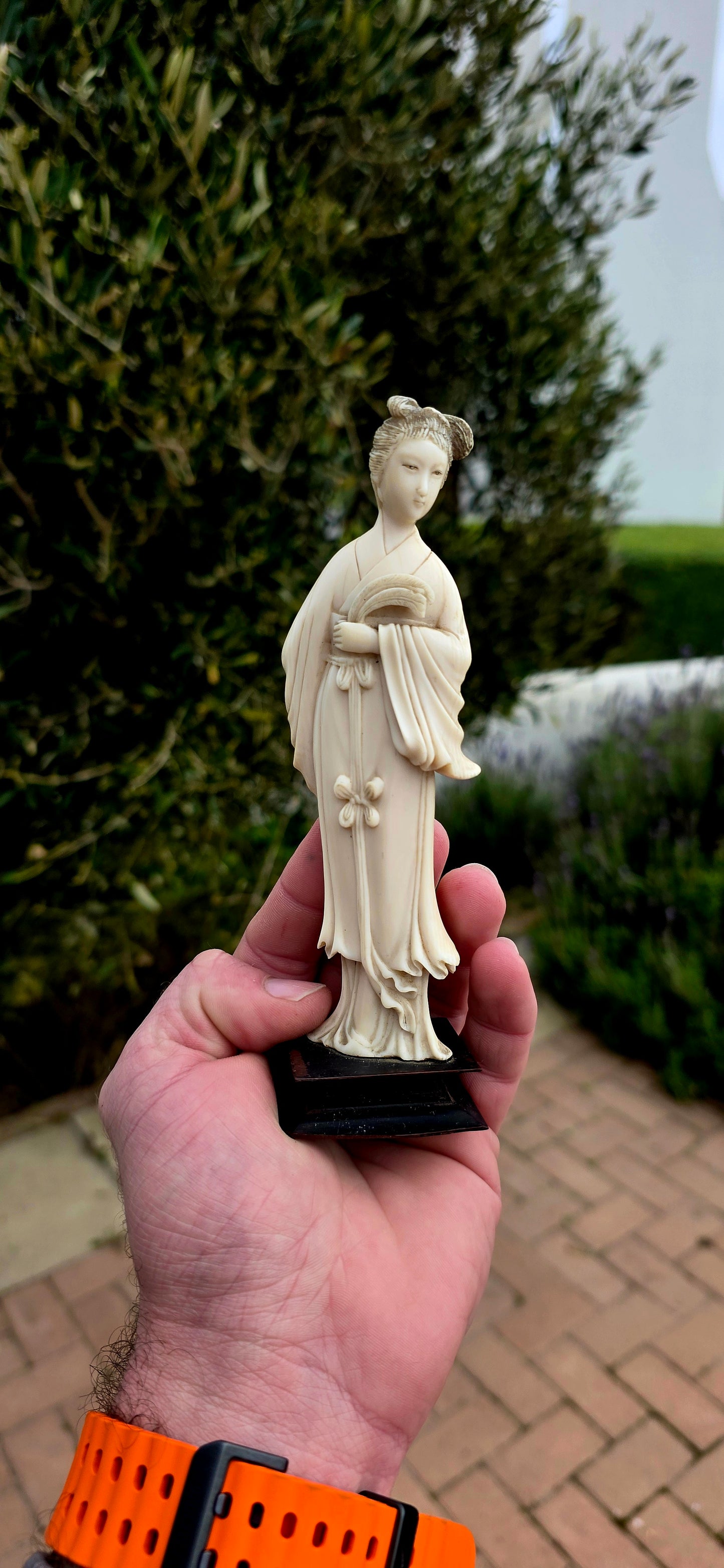 A wonderfully refined 19th-century hand-carved Japanese ivory sculpture, depicting a graceful Bijin (meaning "beautiful woman") elegantly dressed in flowing traditional robes and delicately holding an uchiwa (rigid ceremonial fan).