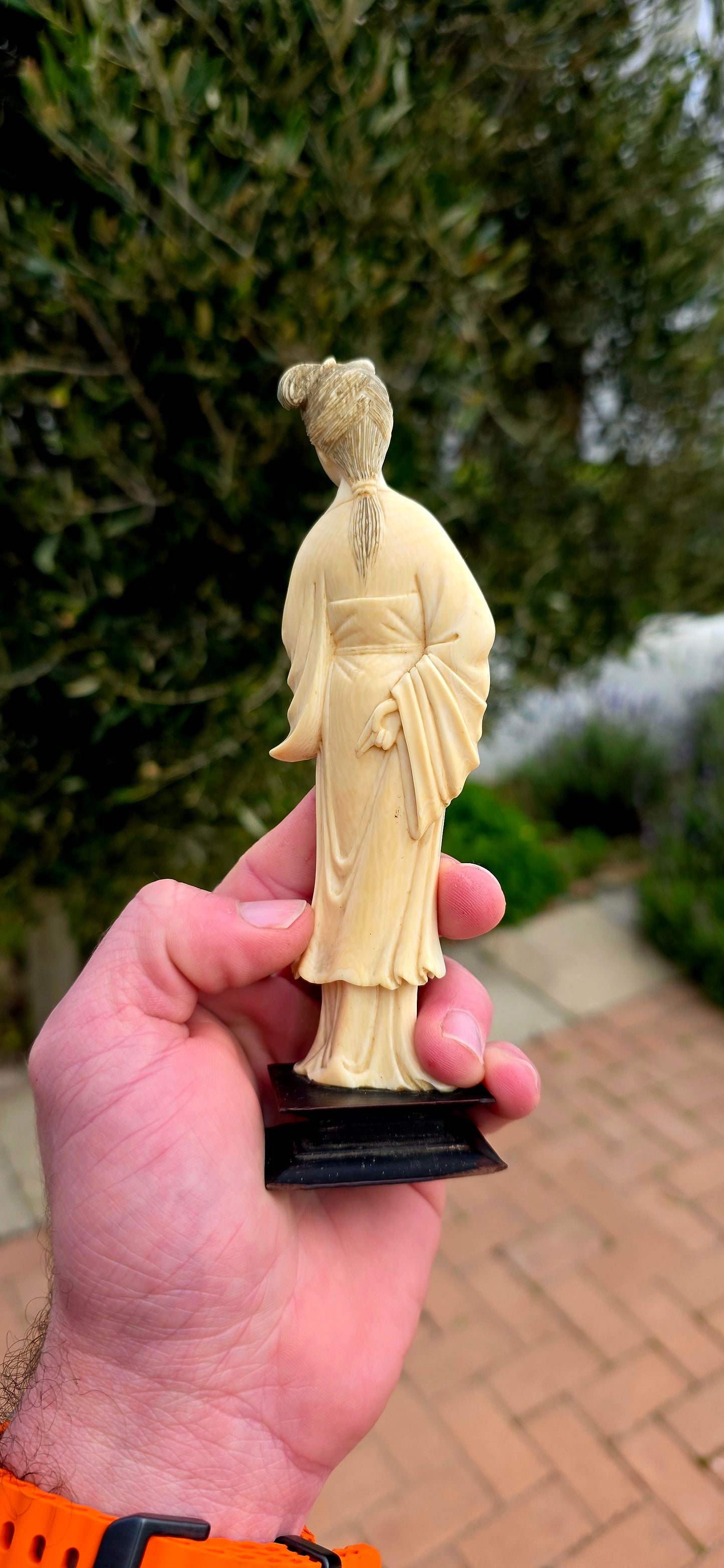 A wonderfully refined 19th-century hand-carved Japanese ivory sculpture, depicting a graceful Bijin (meaning "beautiful woman") elegantly dressed in flowing traditional robes and delicately holding an uchiwa (rigid ceremonial fan).