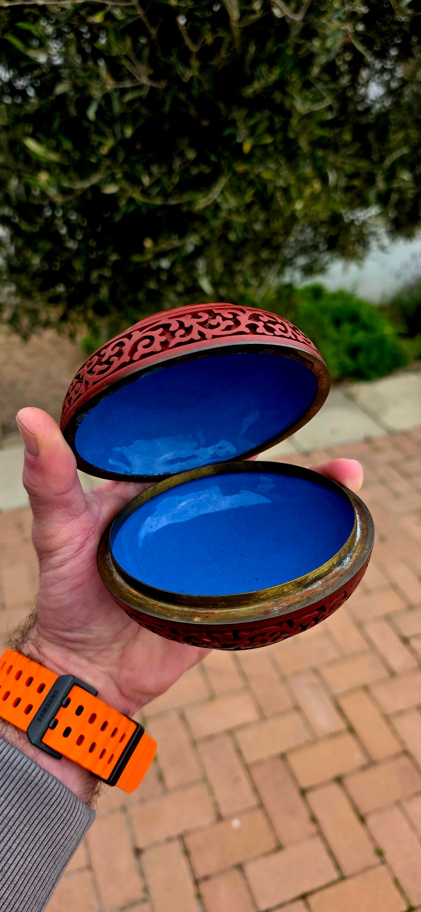 A magnificent Chinese cloisonné enamel and carved cinnabar circular box and lid, beautifully decorated with a tranquil riverside landscape depicting a lone scholar crossing the water toward towering mountains and a secluded pavilion.