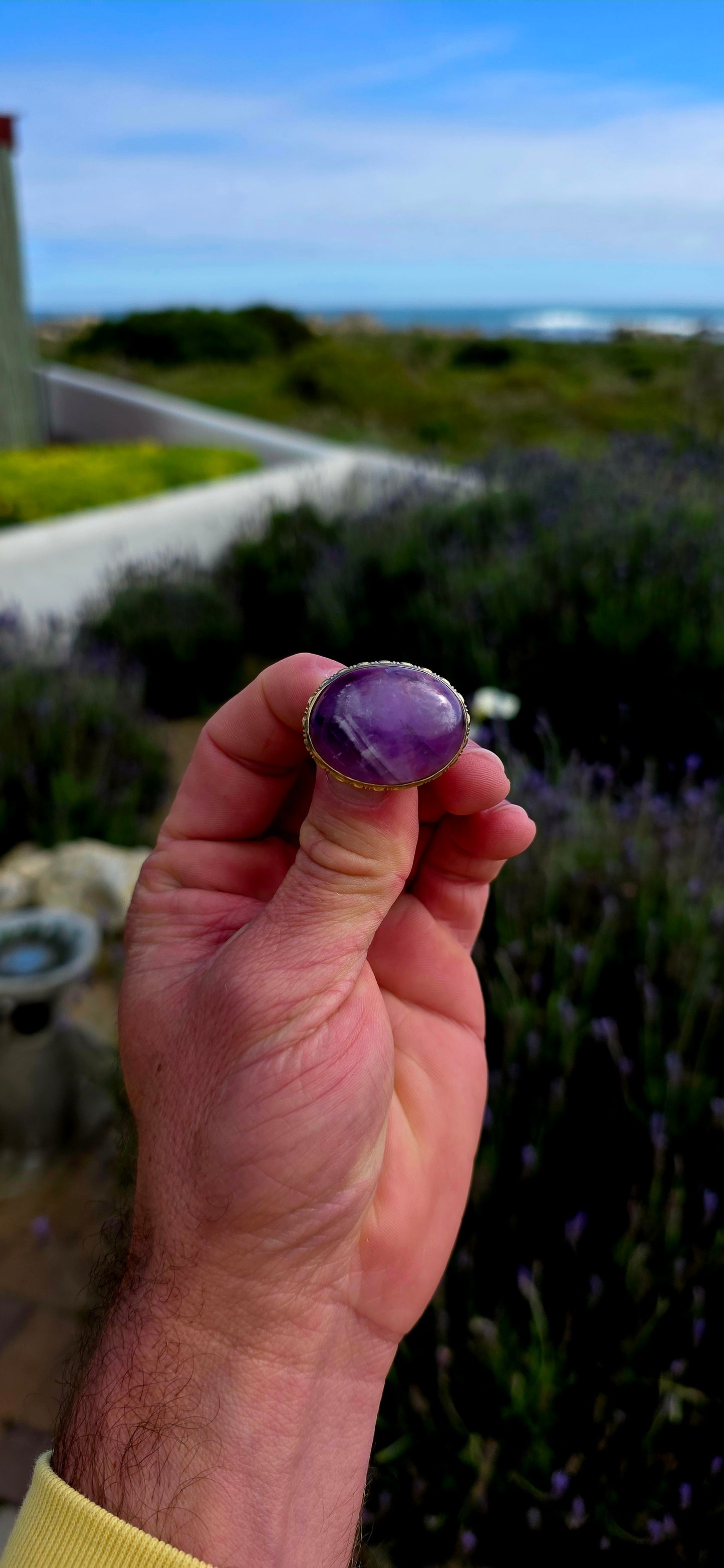 A truly beautiful antique treasure, this 10ct yellow gold brooch showcases a generously sized natural oval amethyst cabochon, celebrated for its rich royal-purple hues and soft, glowing lustre.