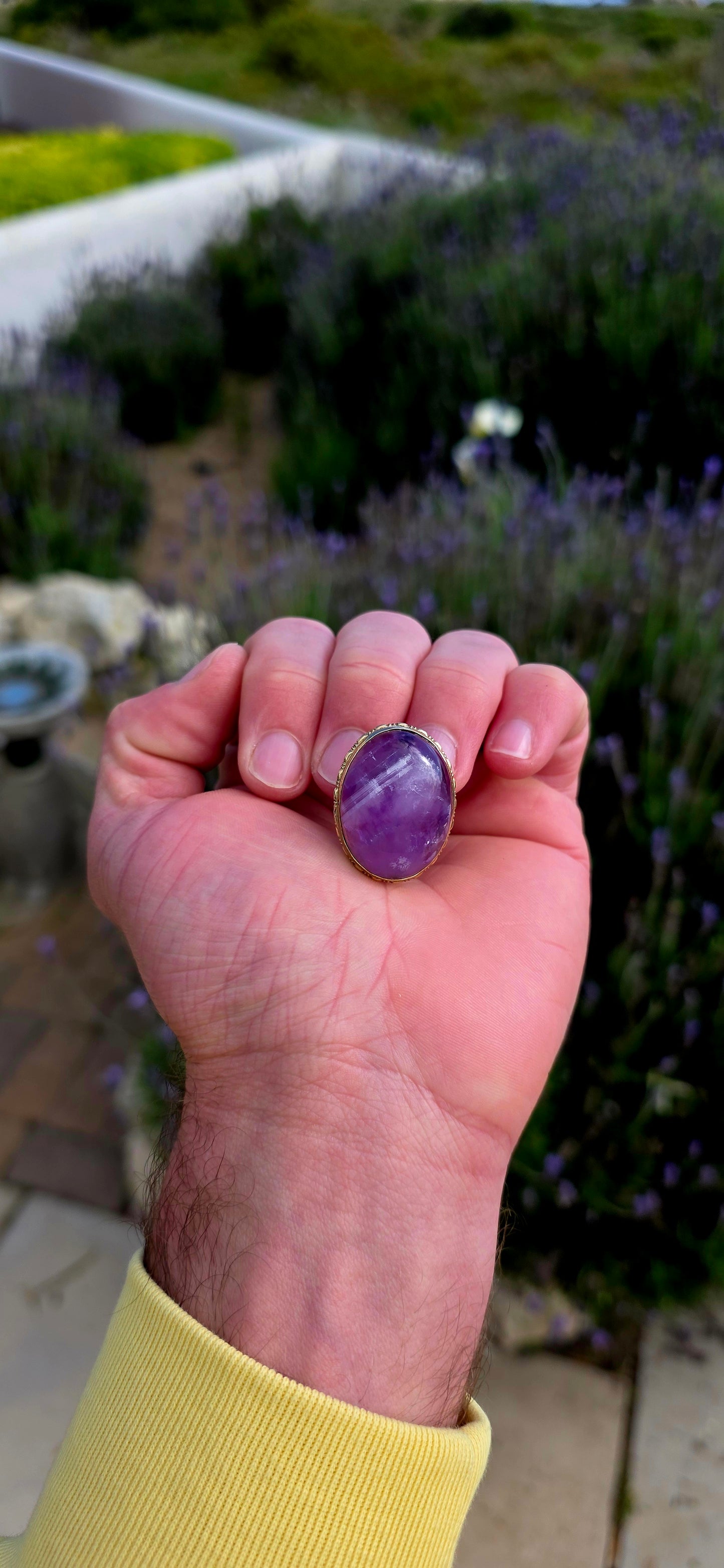 A truly beautiful antique treasure, this 10ct yellow gold brooch showcases a generously sized natural oval amethyst cabochon, celebrated for its rich royal-purple hues and soft, glowing lustre.