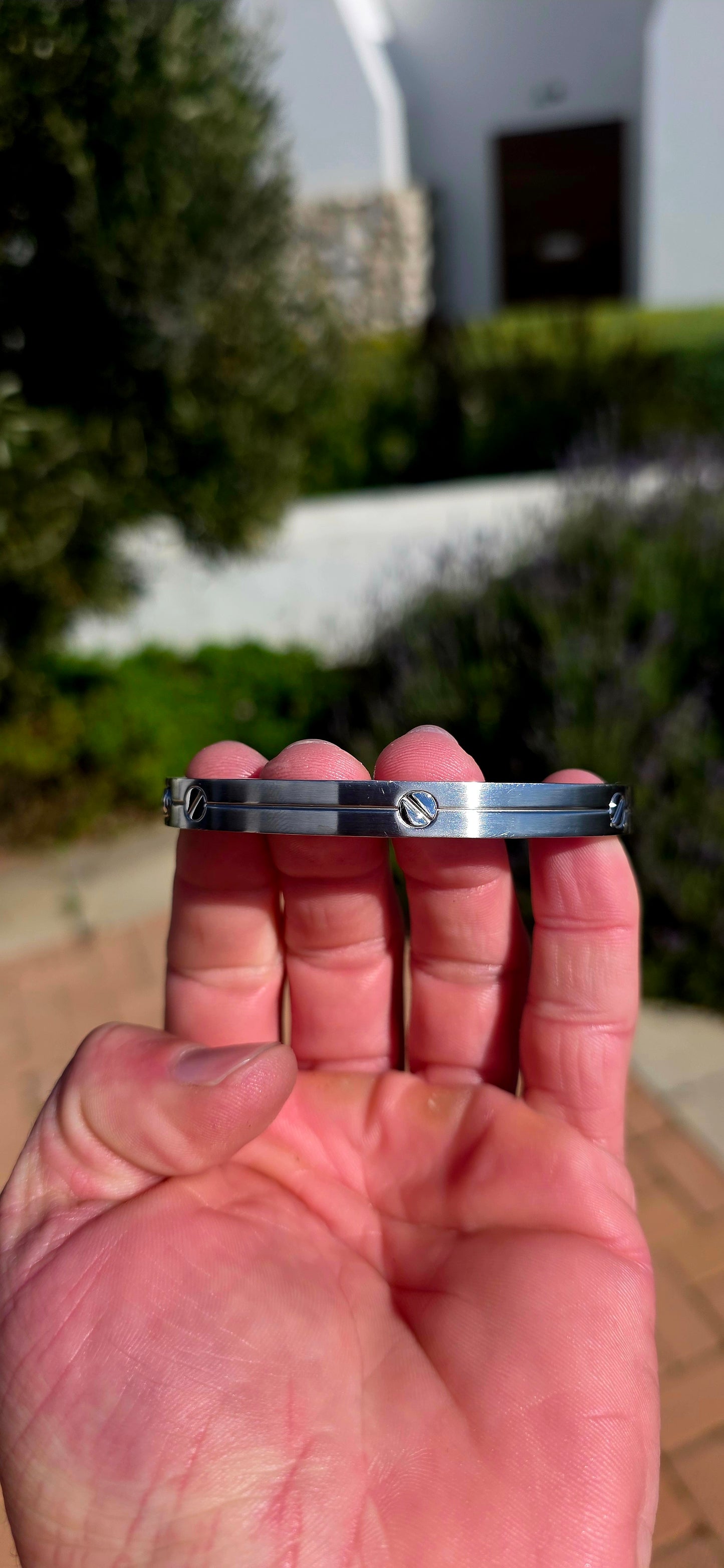 A sleek and timeless Rochet Inox stainless steel clip bangle, finished with the brand's iconic screw motif for a bold, industrial-inspired aesthetic.