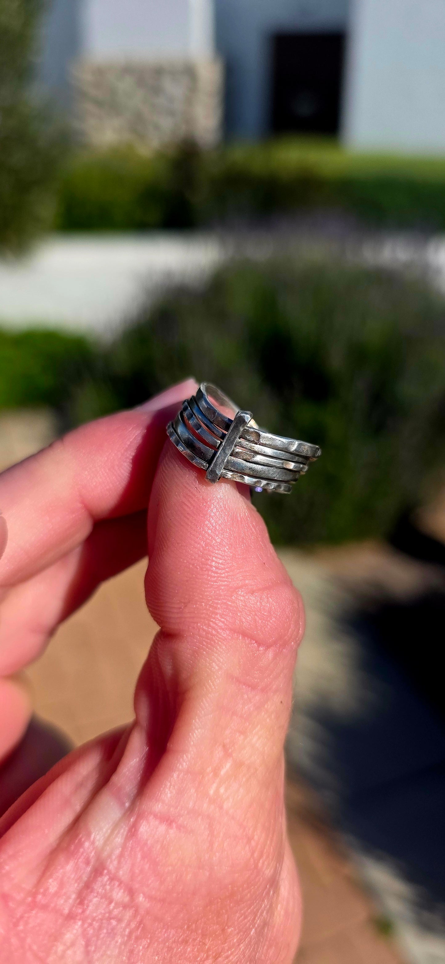 A beautifully handcrafted statement ring featuring five individual sterling silver bands, each finished with its own unique texture and character.