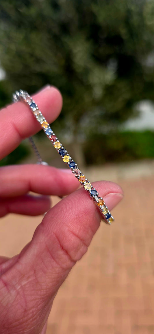 Vibrant ans elegant ... this beautiful unisex sterling silver tennis bracelet is a celebration of colour, featuring a dazzling spectrum of natural sapphires.