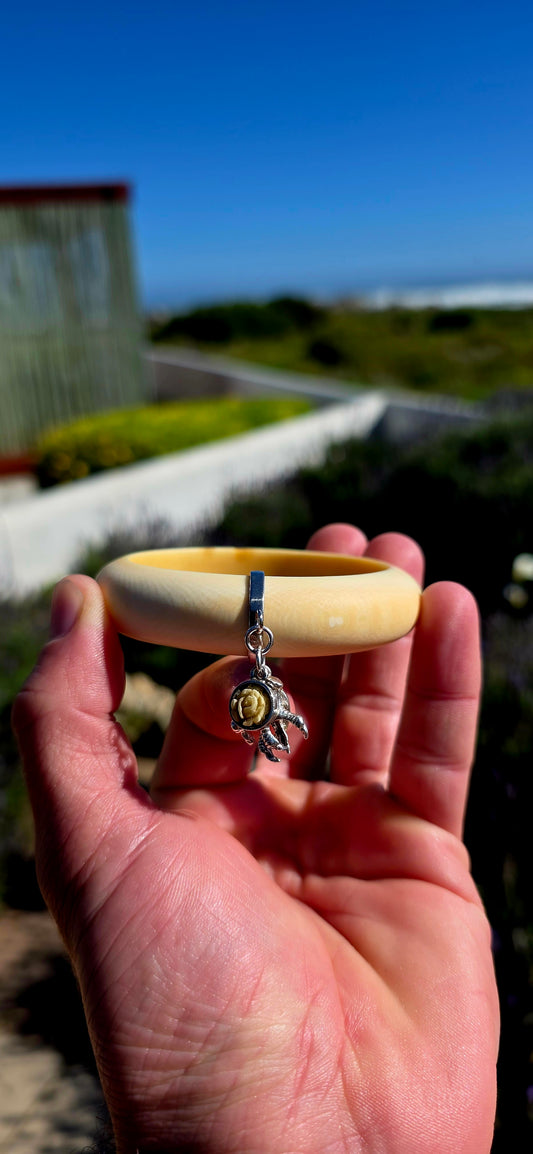 Wonderfully unique, beautifully symbolic, and rich in vintage character... this vintage pre-ban ivory bangle is a delightful piece of wearable history, bringing together craftsmanship with meaningful lucky charms.