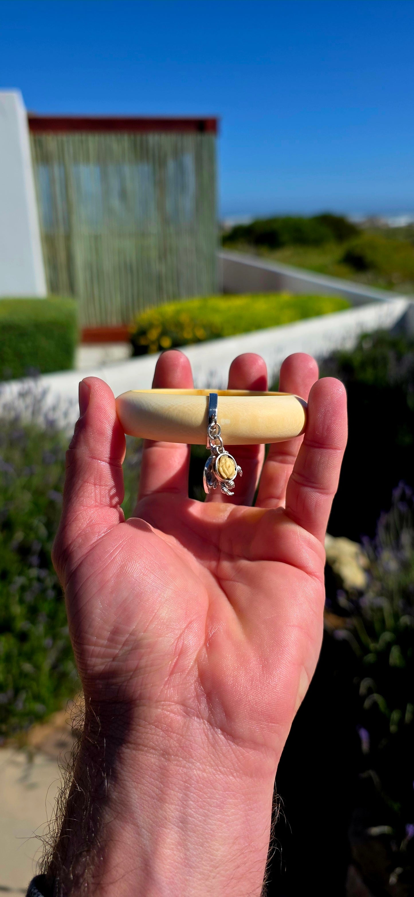 Wonderfully unique, beautifully symbolic, and rich in vintage character... this vintage pre-ban ivory bangle is a delightful piece of wearable history, bringing together craftsmanship with meaningful lucky charms.