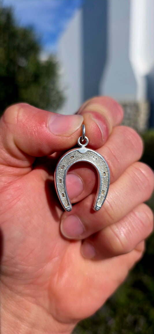 A symbol of good fortune, this oversized vintage sterling silver horseshoe pendant is both bold and wonderfully versatile.
