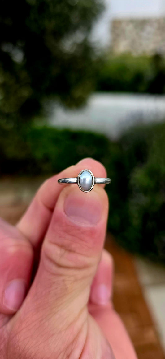 Elegant in its simplicity and timeless in its appeal... this beautifully handmade sterling silver solitaire ring showcases a luminous oval Mabe pearl in the most enchanting soft grey-blue hue.